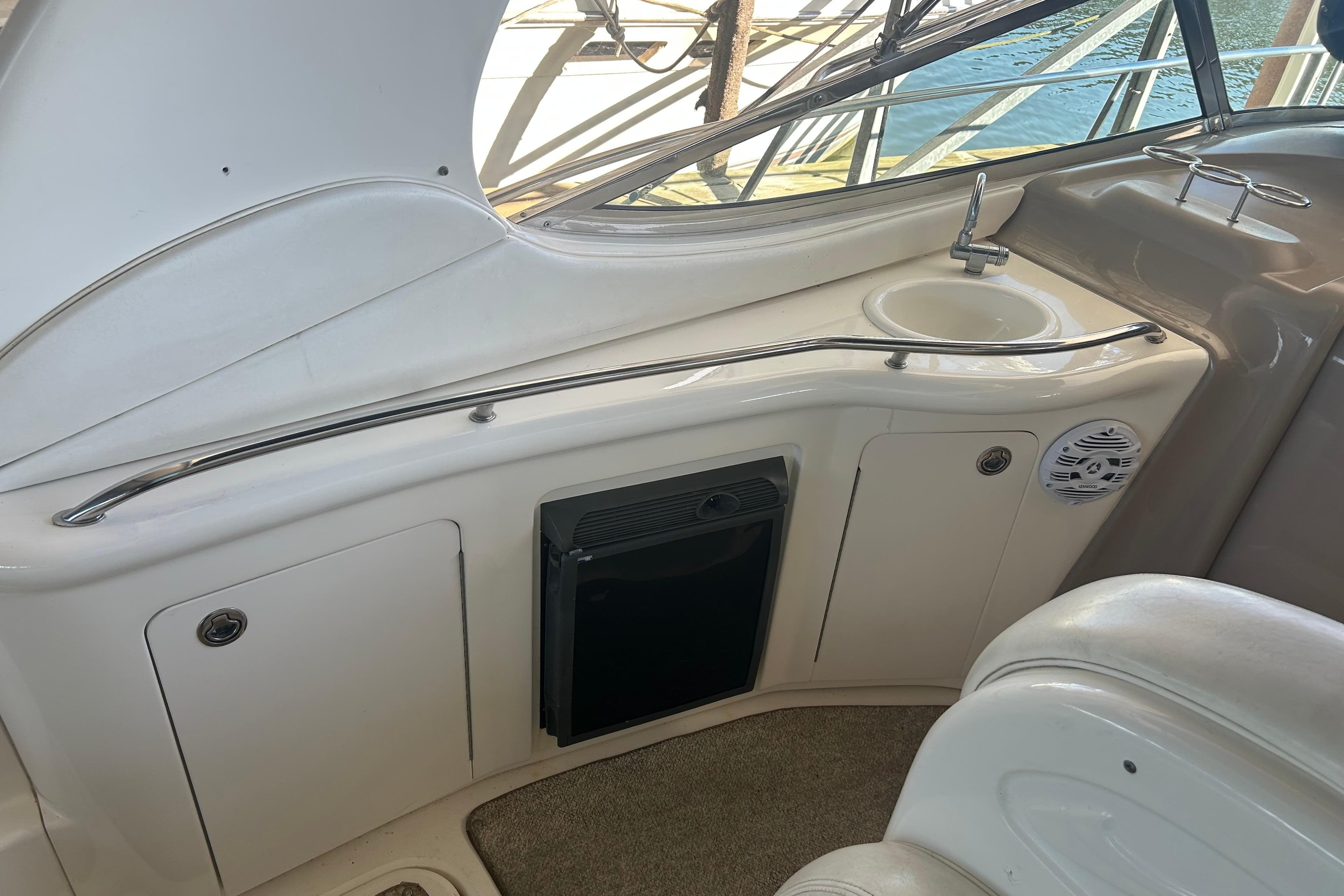 2005 Sea Ray 300 Sundancer boat interior with sink and storage cabinets.