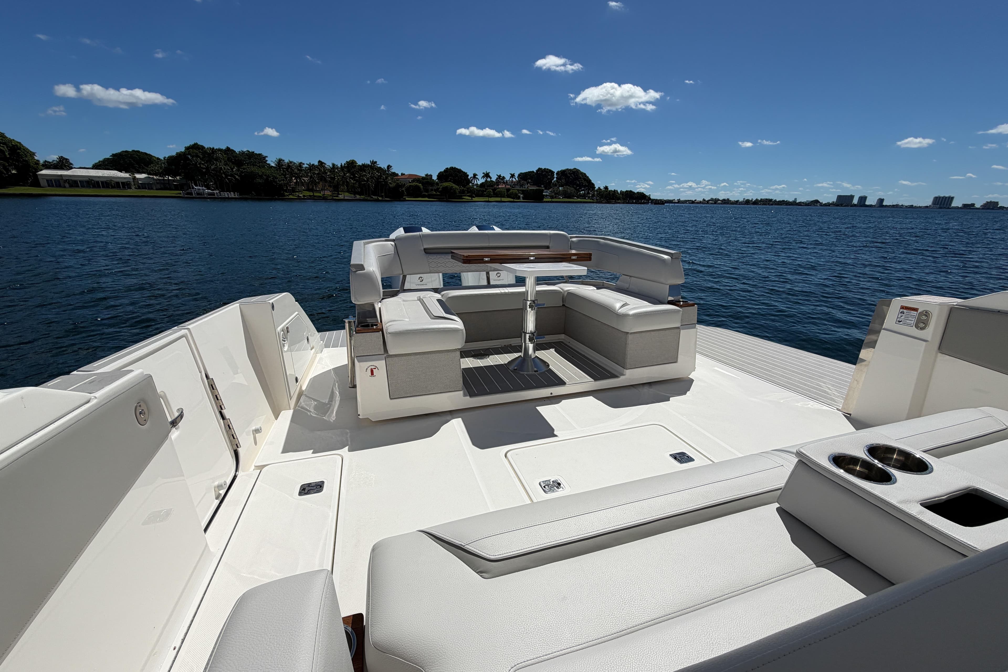 2024 Tiara Yachts 43 LS luxury deck with seating, overlooking serene water and clear sky.