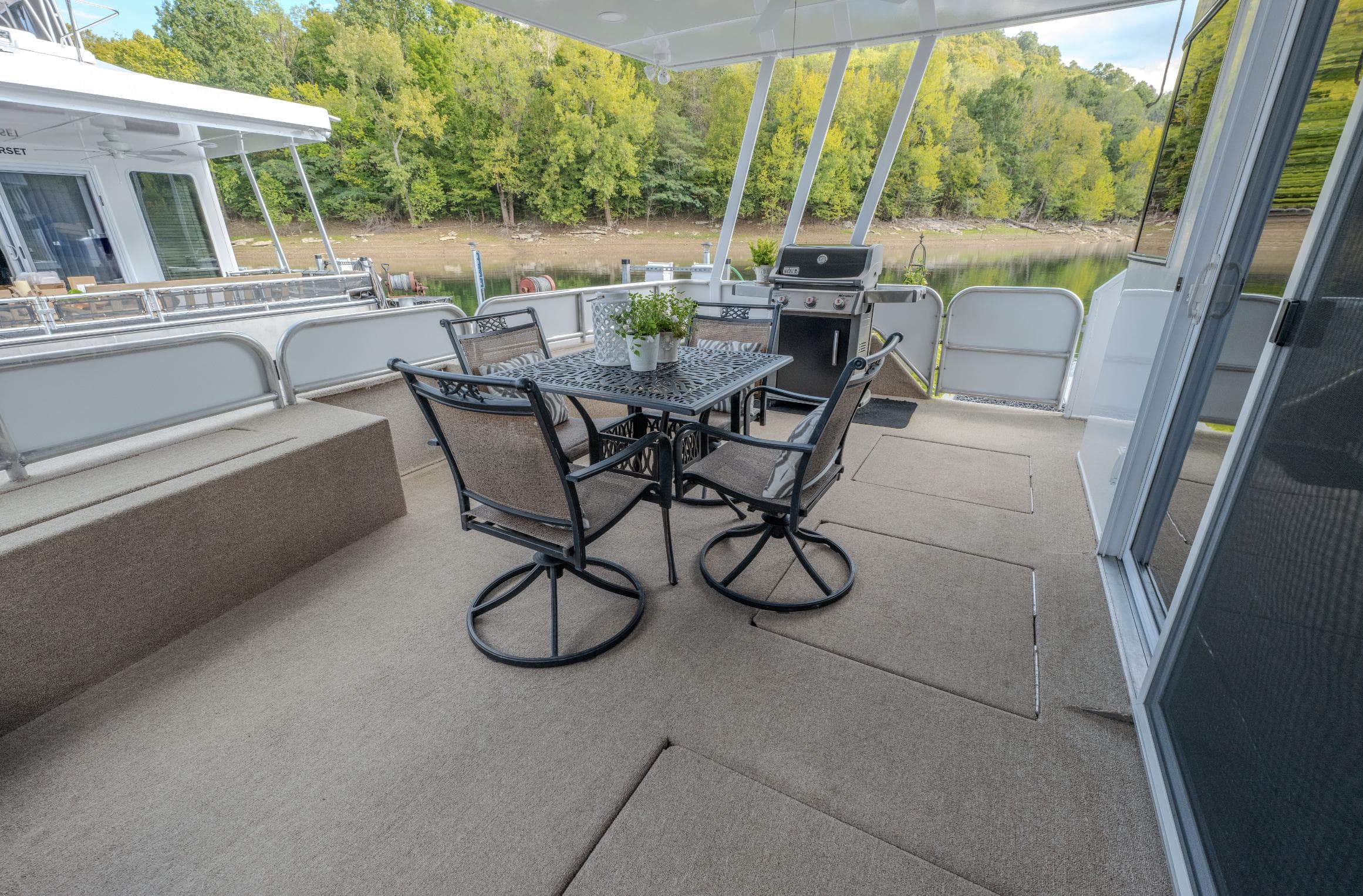 Spacious deck on 2007 Fantasy 19 X 90 houseboat with outdoor dining set and grill.