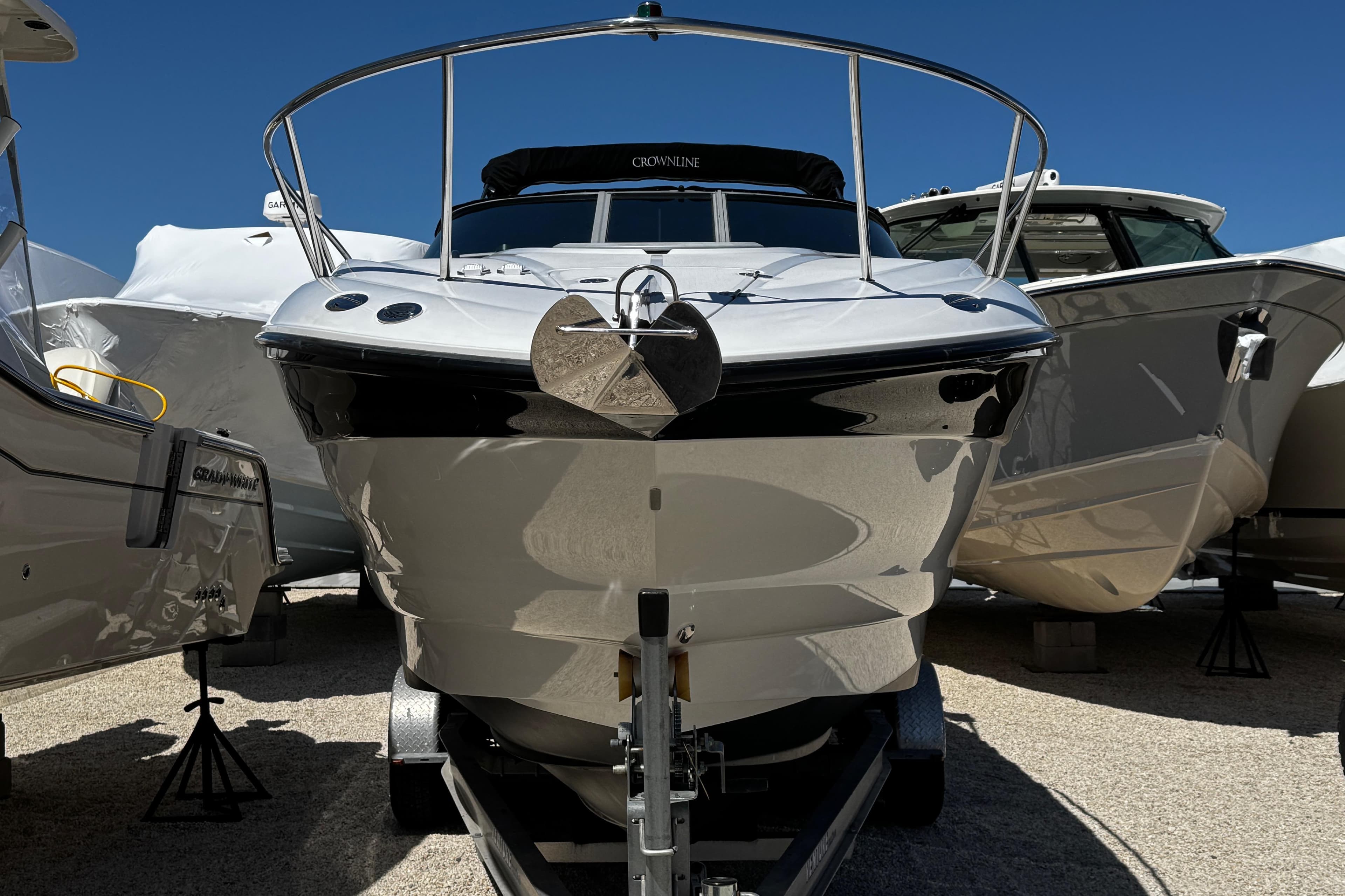 2004 Crownline 250 CR boat on trailer, surrounded by other boats, under clear blue sky.