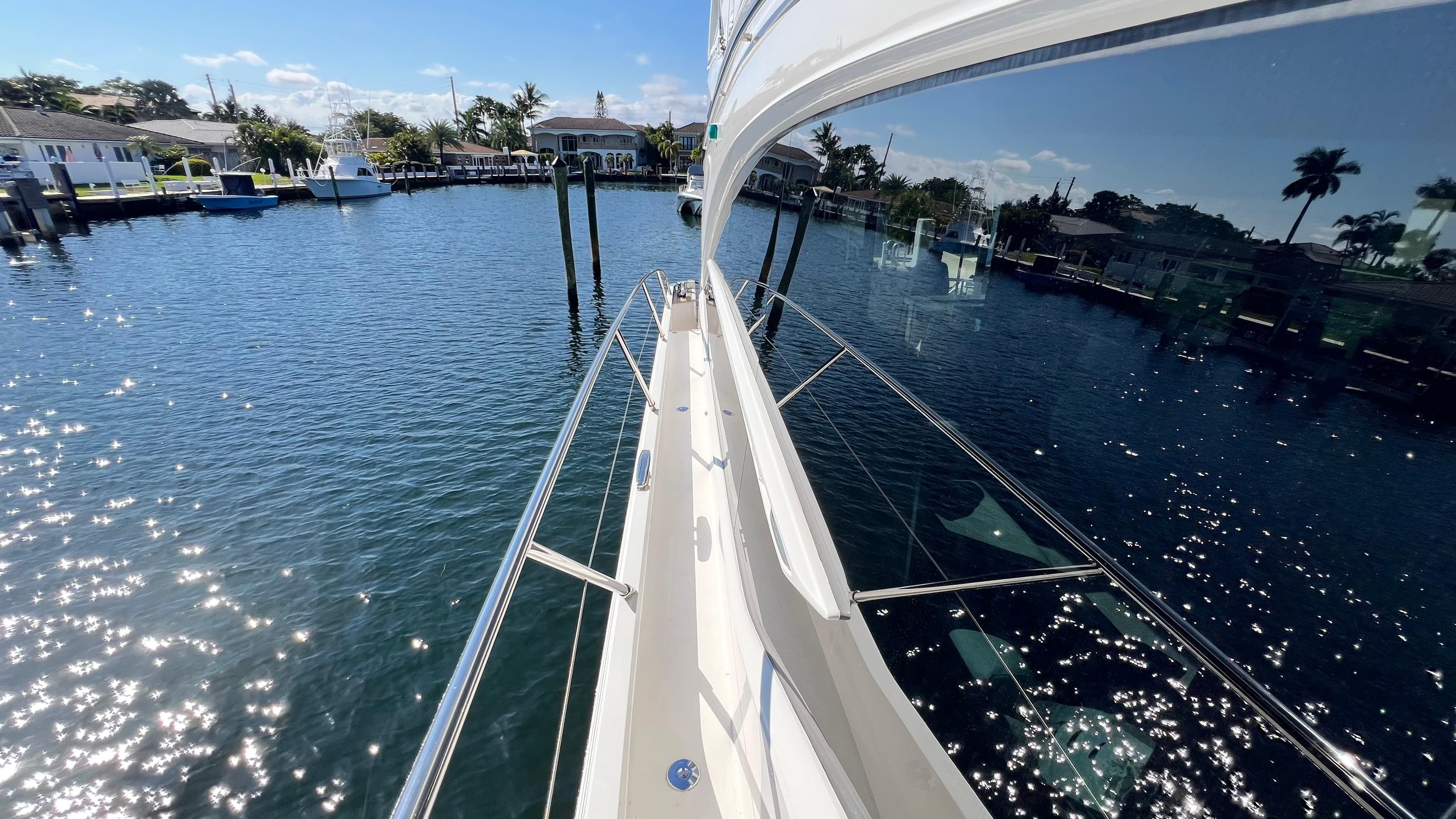 Luxurious 2019 Princess F62 yacht on sparkling water, reflecting a sunny marina view.