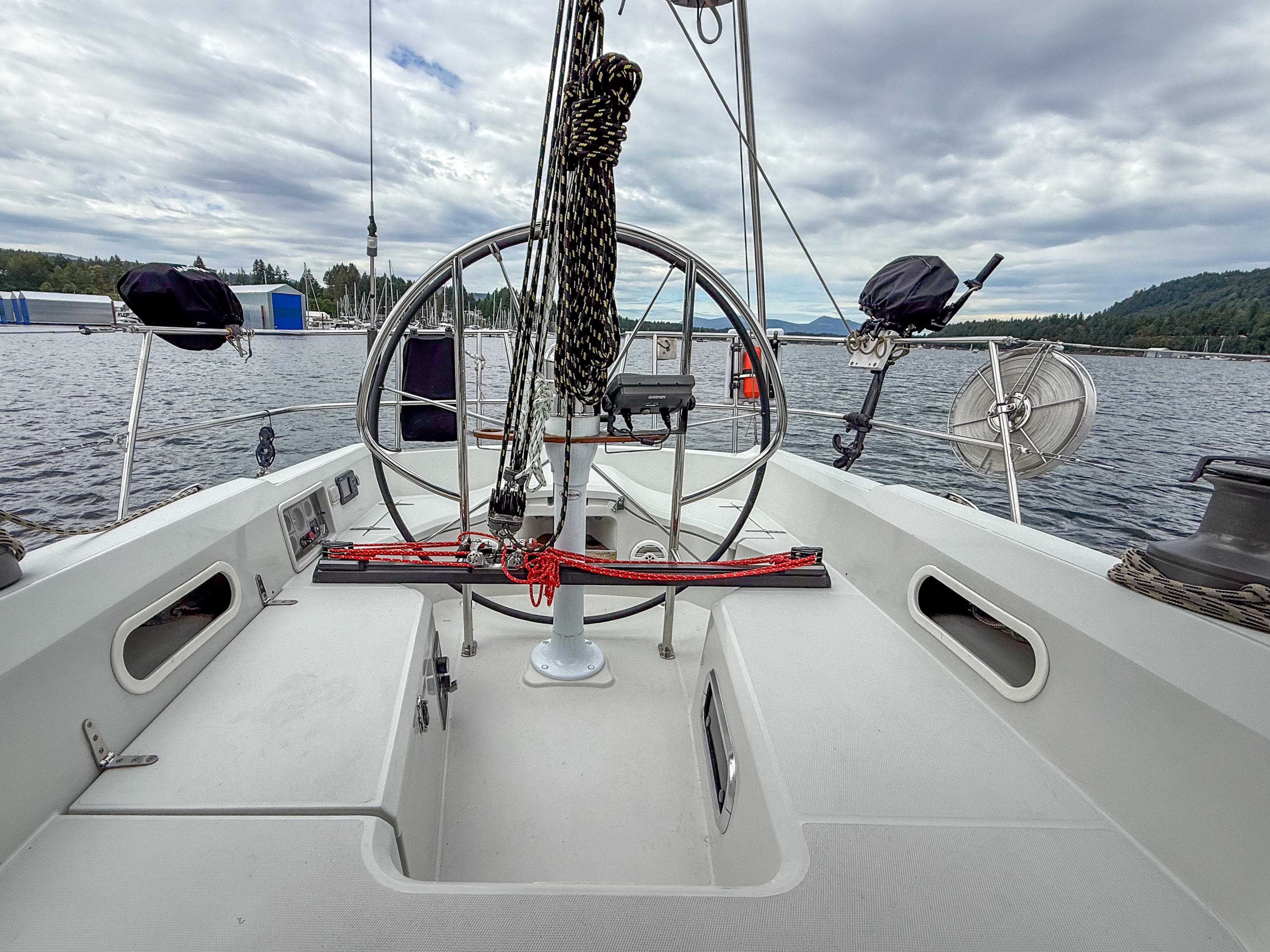 Sailboat cockpit view, Sabre 402, 1997 model, on a calm lake under cloudy skies.