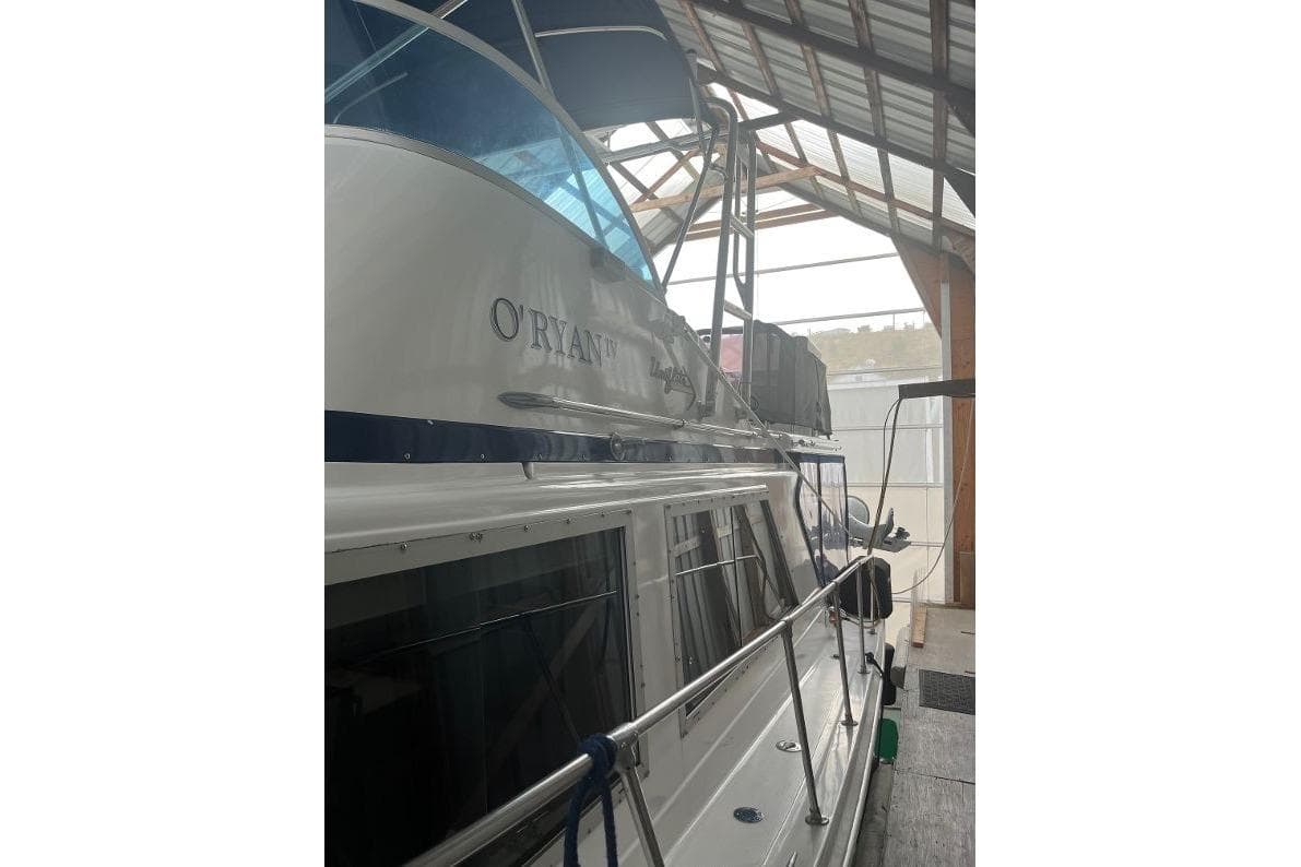 1976 Uniflite 32 Sport Sedan docked in a covered marina.
