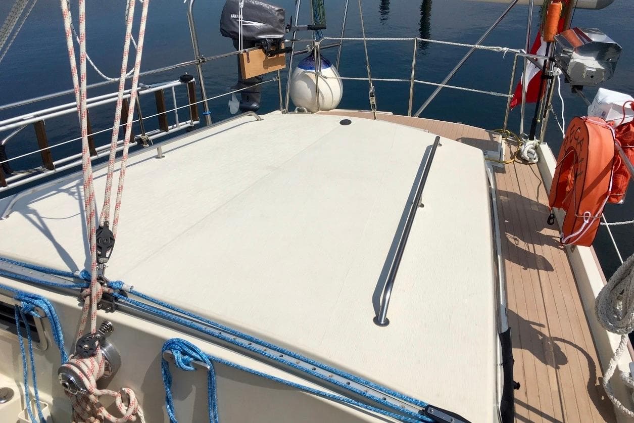 1993 Amel Santorin Sloop deck with ropes, life preserver, and railing in a marina setting.