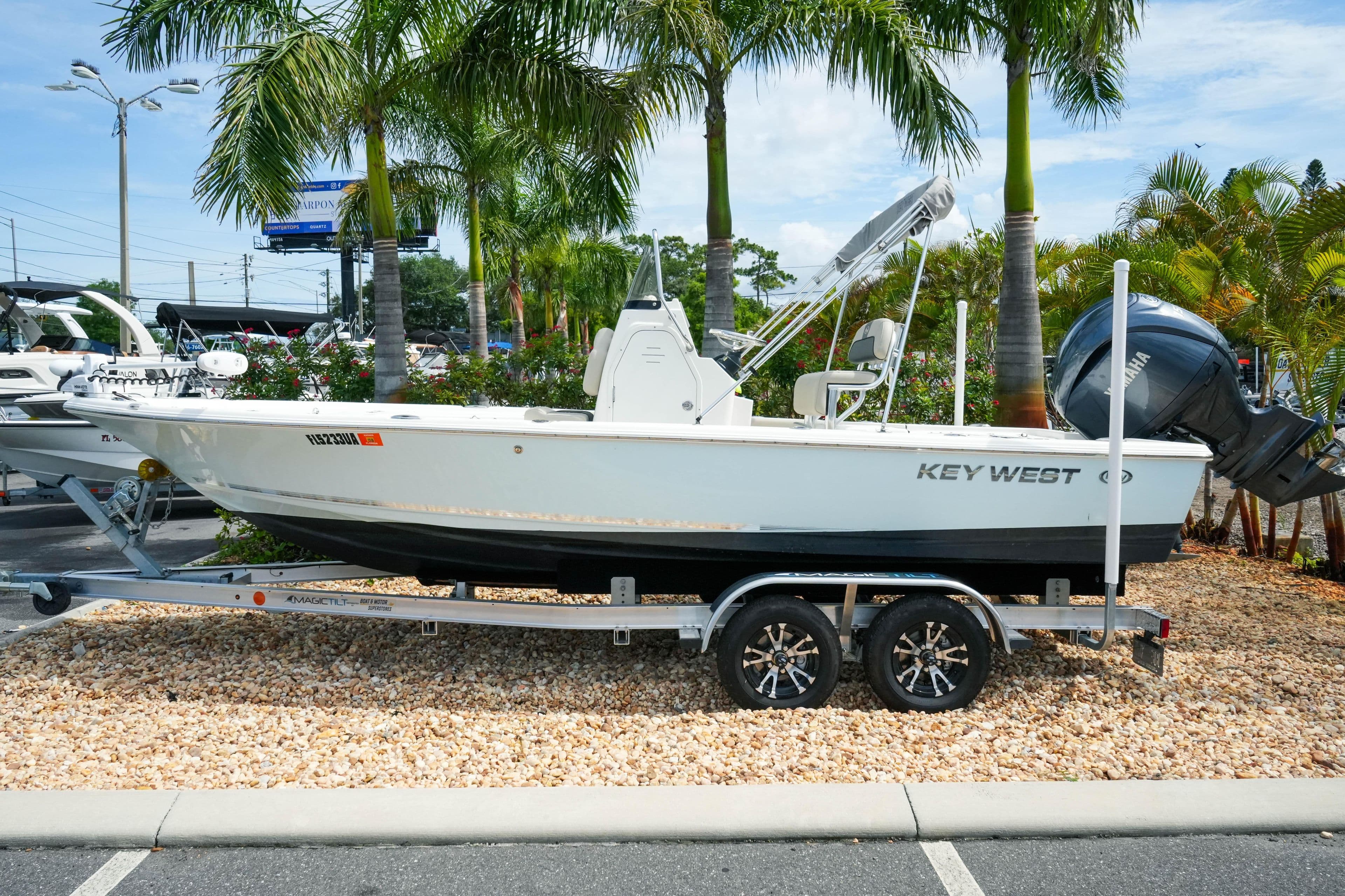 2025 Key West 210 Bay Reef boat on trailer, surrounded by palm trees.
