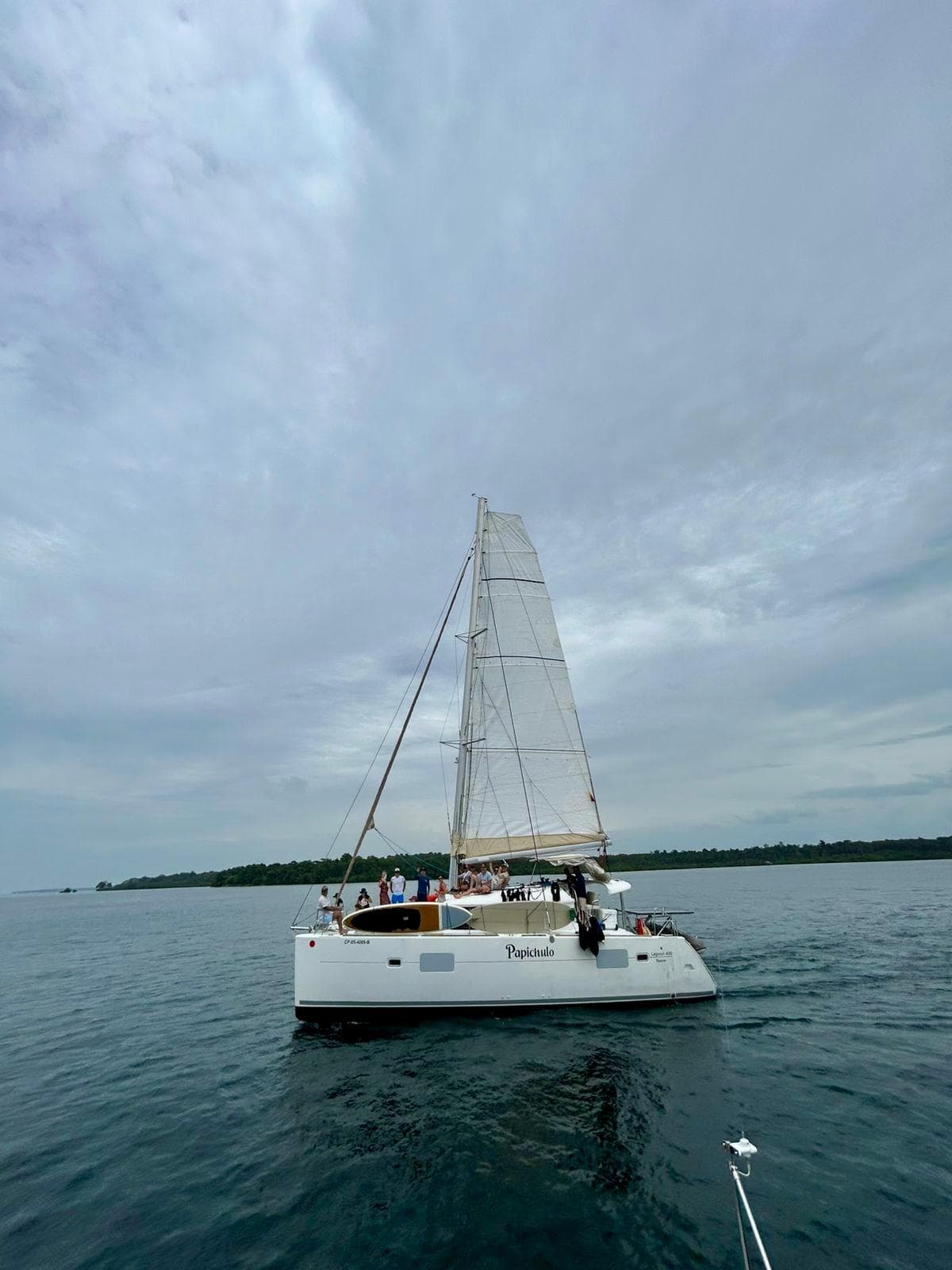 2010 Lagoon 400 catamaran sailing on calm waters under a cloudy sky.