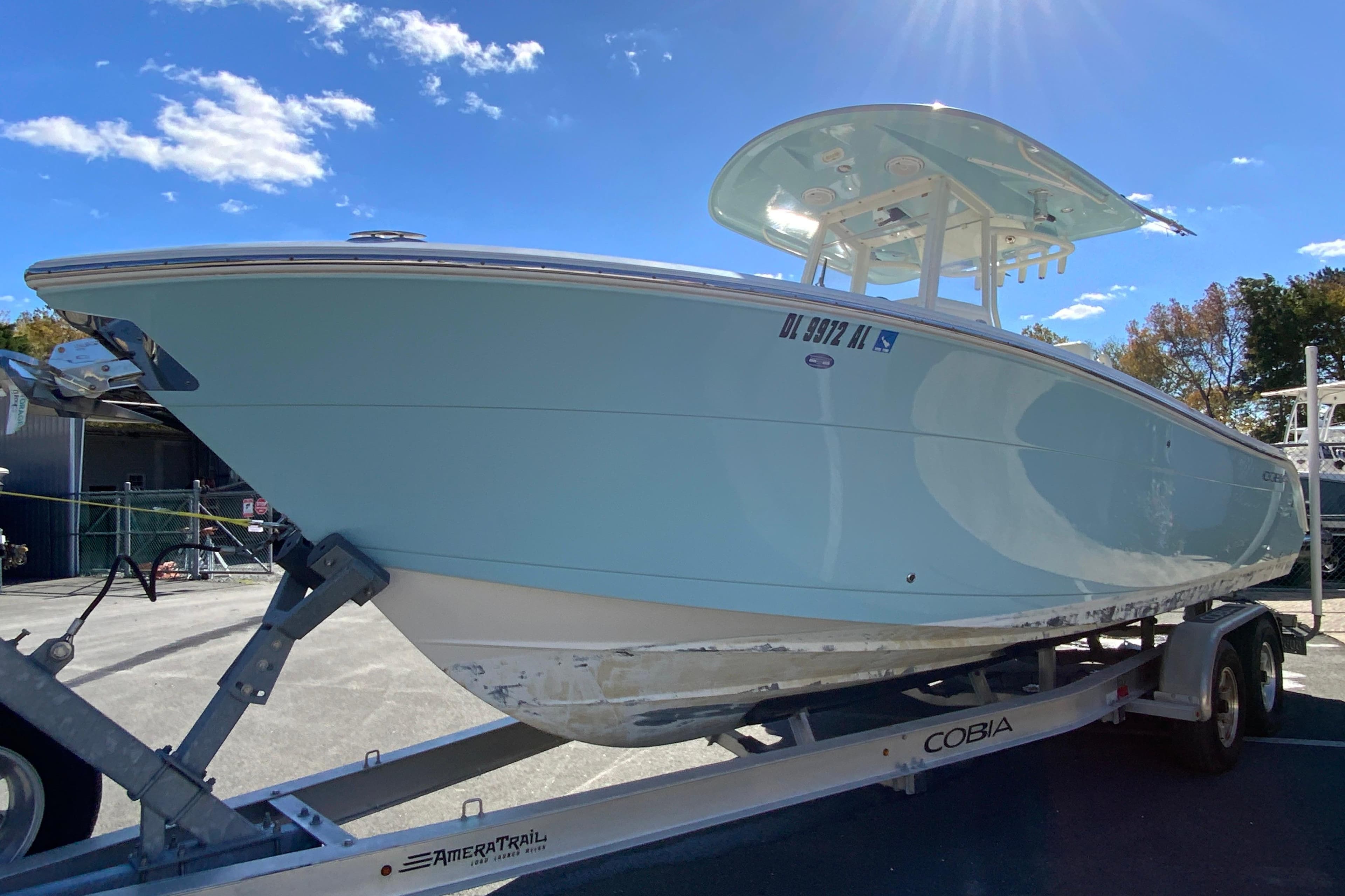 2019 Cobia 262 Center Console boat on trailer under clear blue sky.
