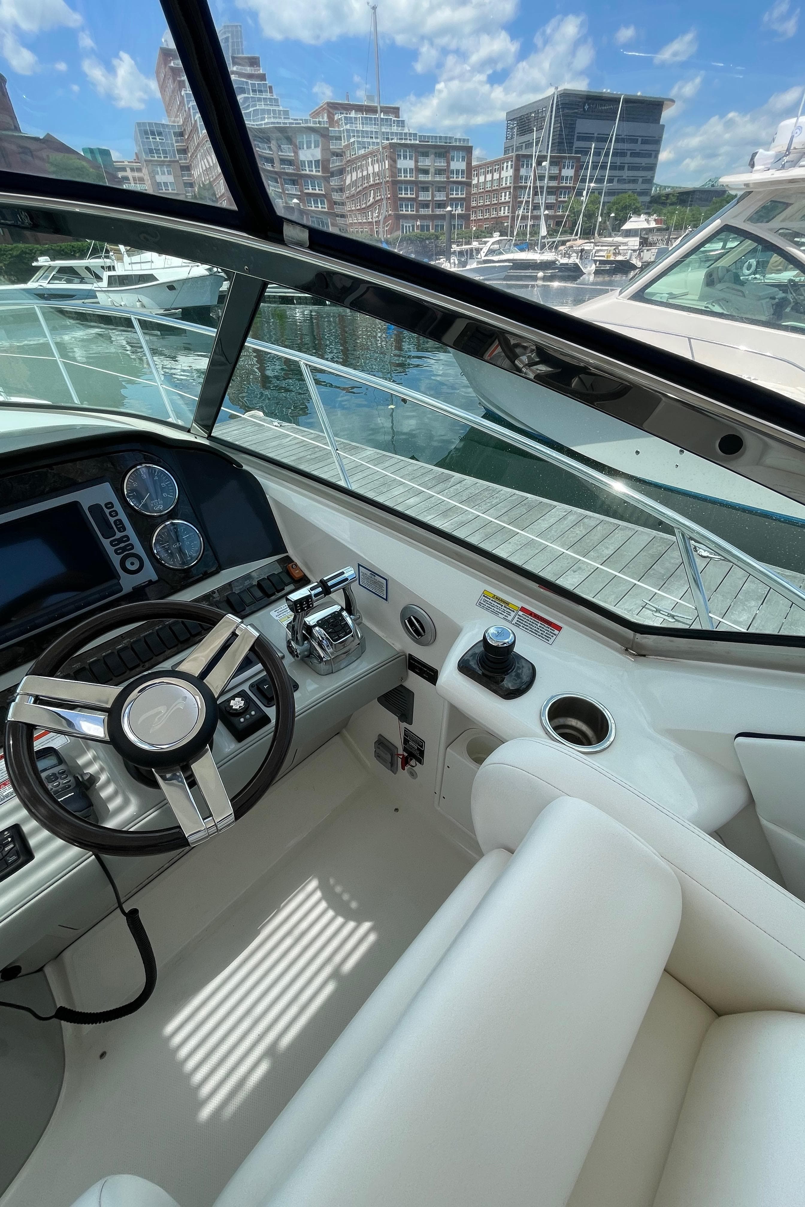 2011 Sea Ray 390 Sundancer cockpit with modern controls, docked at marina.