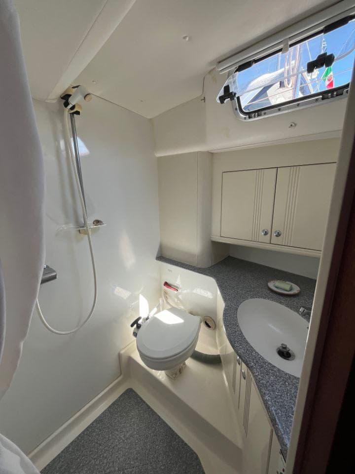 Najad 460 (2001) yacht bathroom with shower, sink, and toilet, featuring modern fixtures and natural light.
