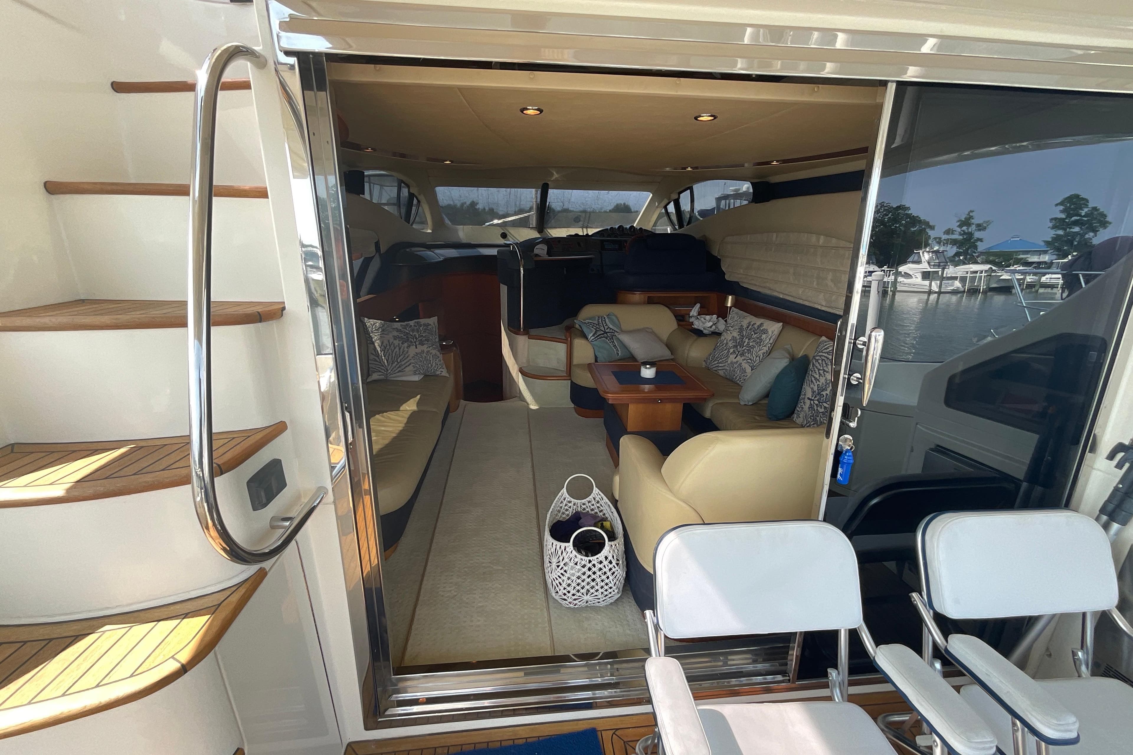 Luxurious interior of 2005 Azimut Fly 50 yacht with elegant seating and scenic marina view.