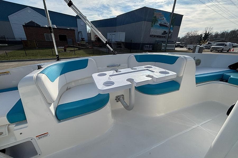 2021 Bayliner Element E16 boat interior with blue seating and a white table.