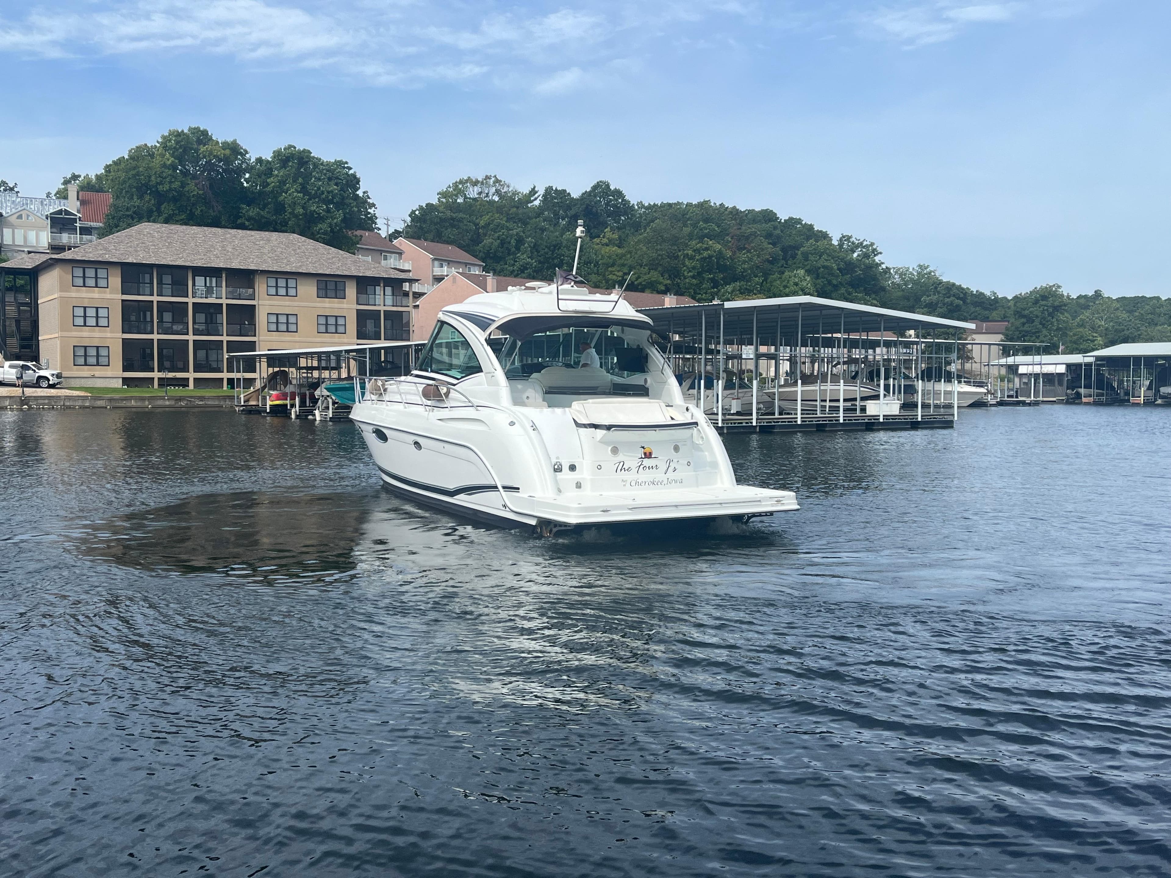 2014 Formula 45 Yacht on a serene lake near waterfront buildings.