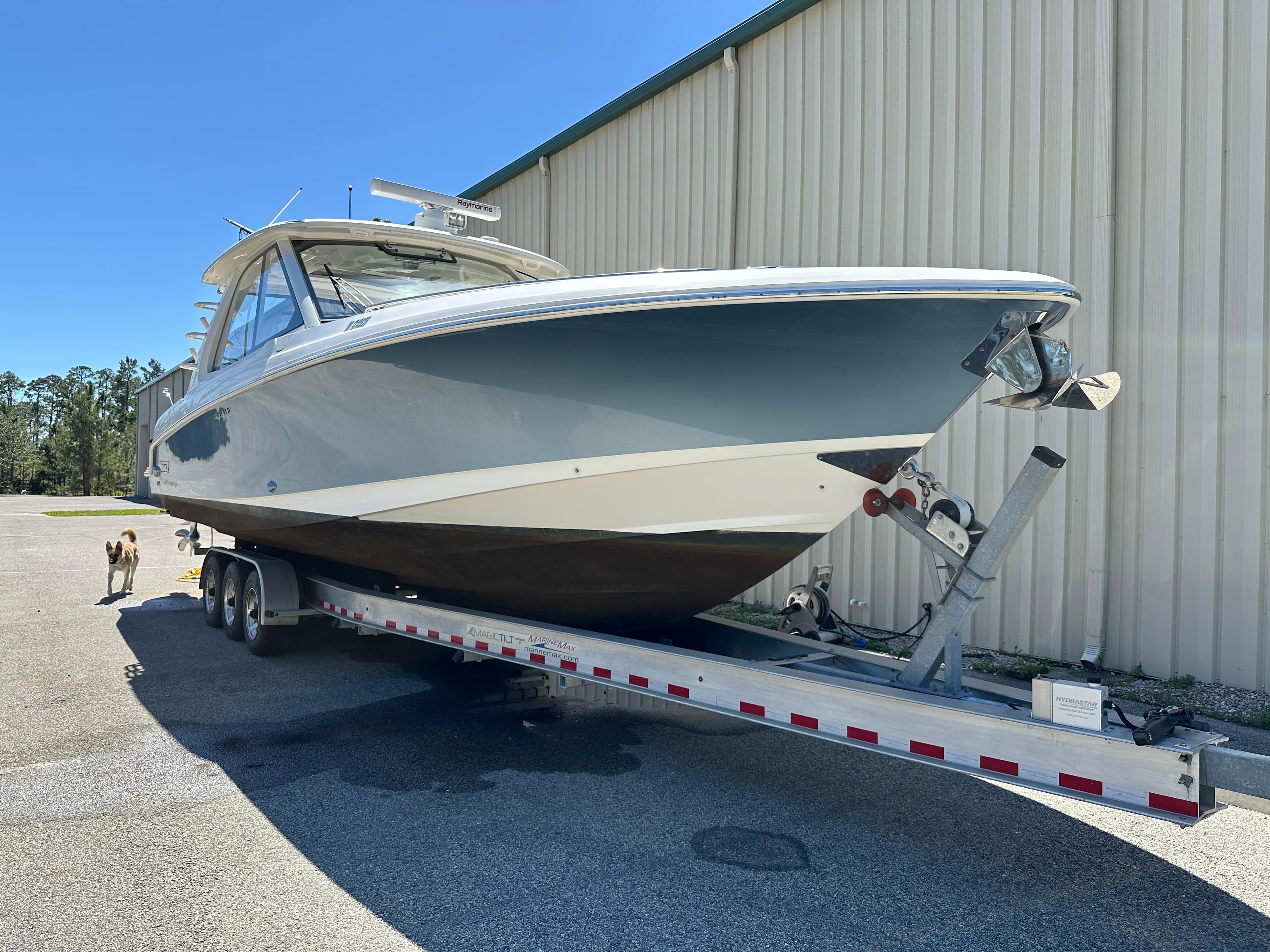 2021 Boston Whaler Realm 380 boat on trailer near a large building.
