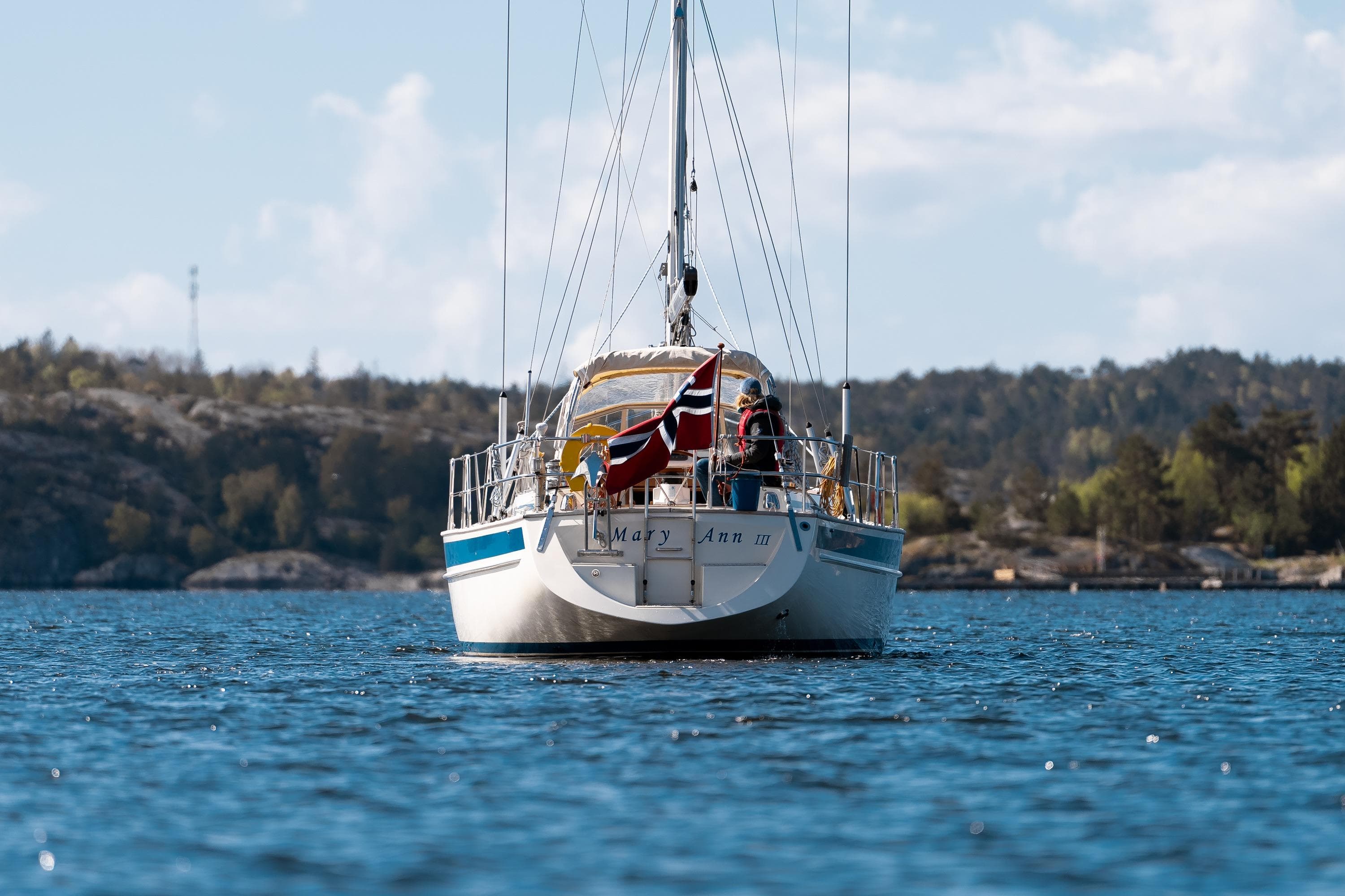 Sailboat Malo 42 (1997) on water, Norwegian flag, scenic background.