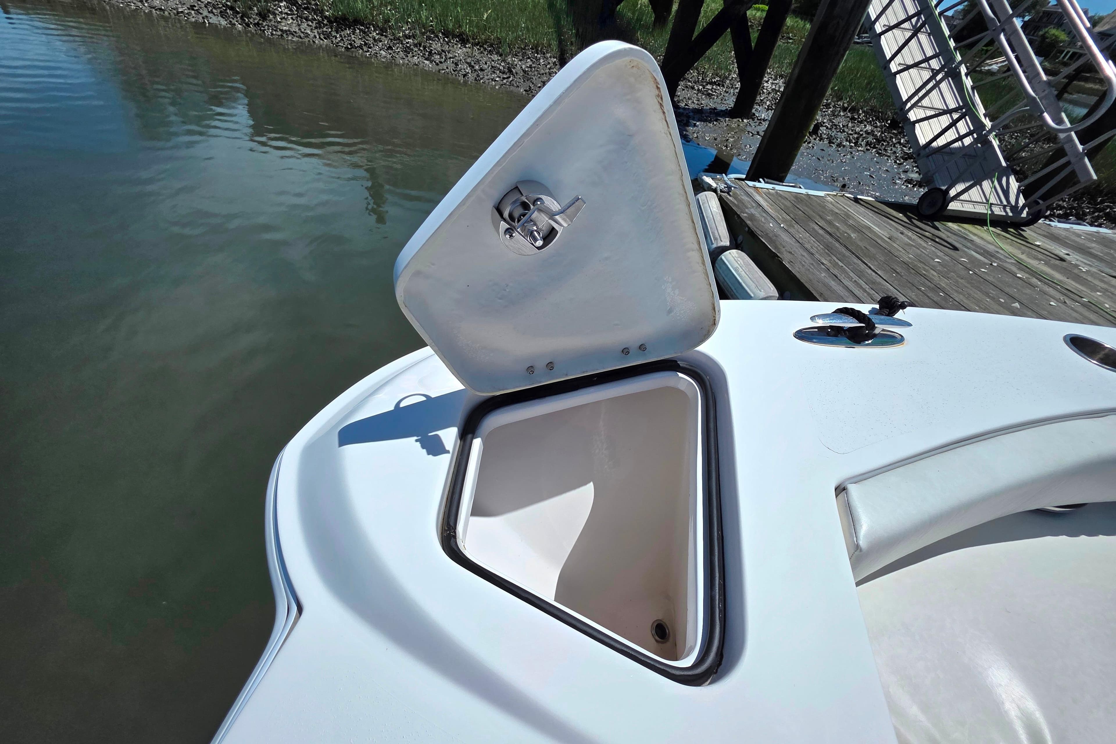 Open storage compartment on 2023 Twin Vee 240 GFX CC boat at dockside.