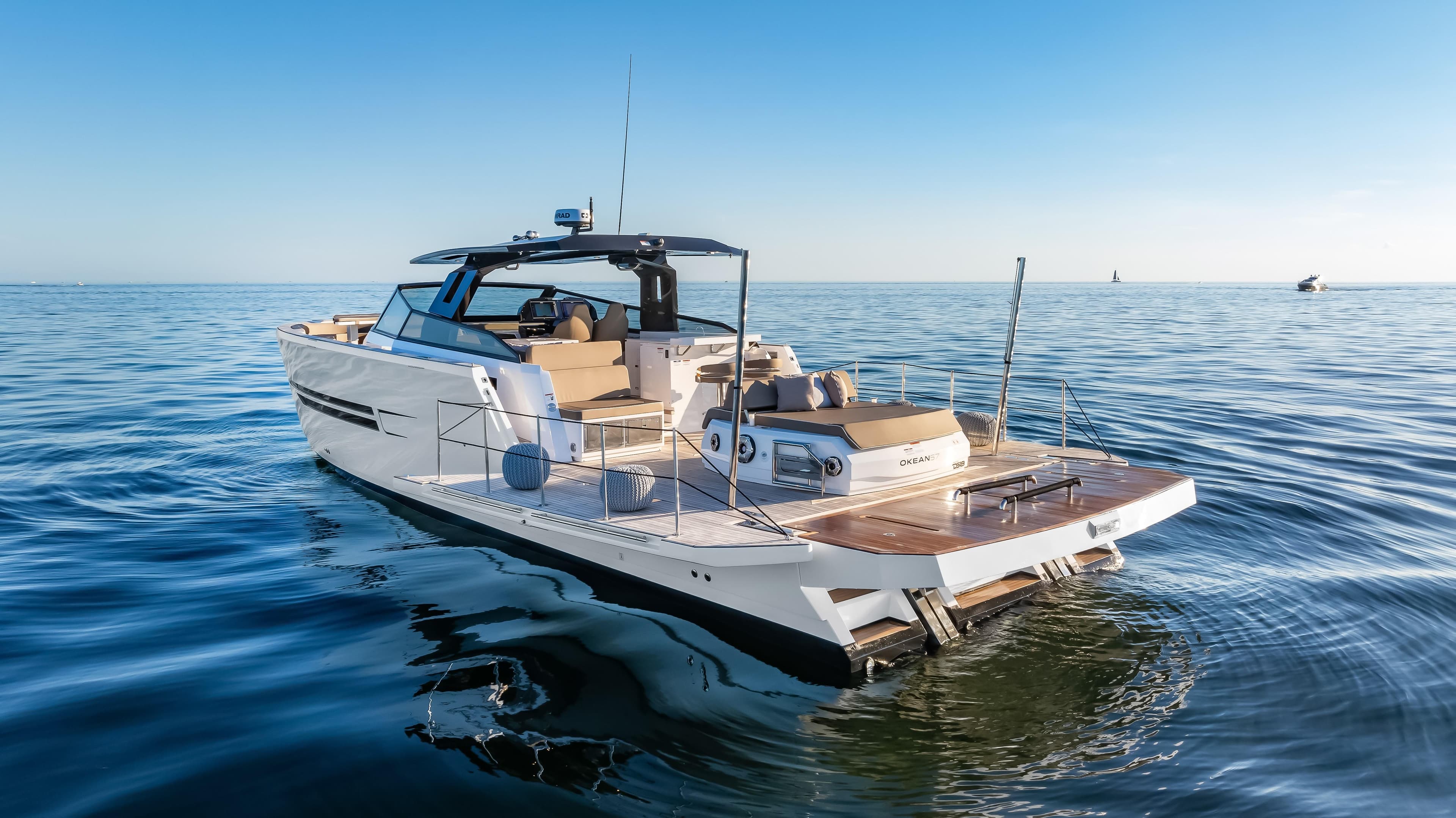 2026 OKEAN 57 yacht cruising on calm ocean waters under clear blue sky.