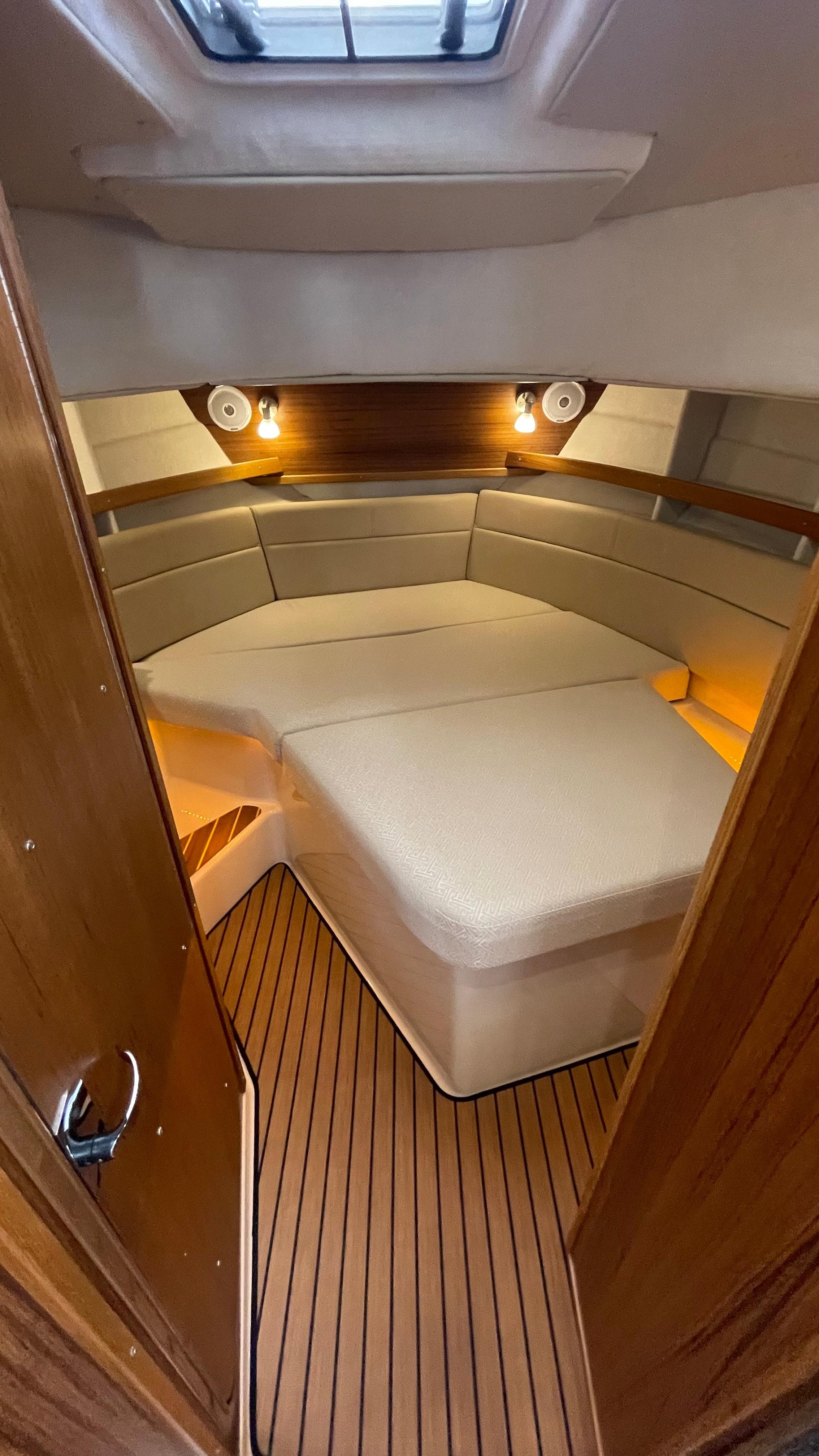 2023 Ranger Tugs R-31 CB cabin interior with cozy bed and wooden flooring.