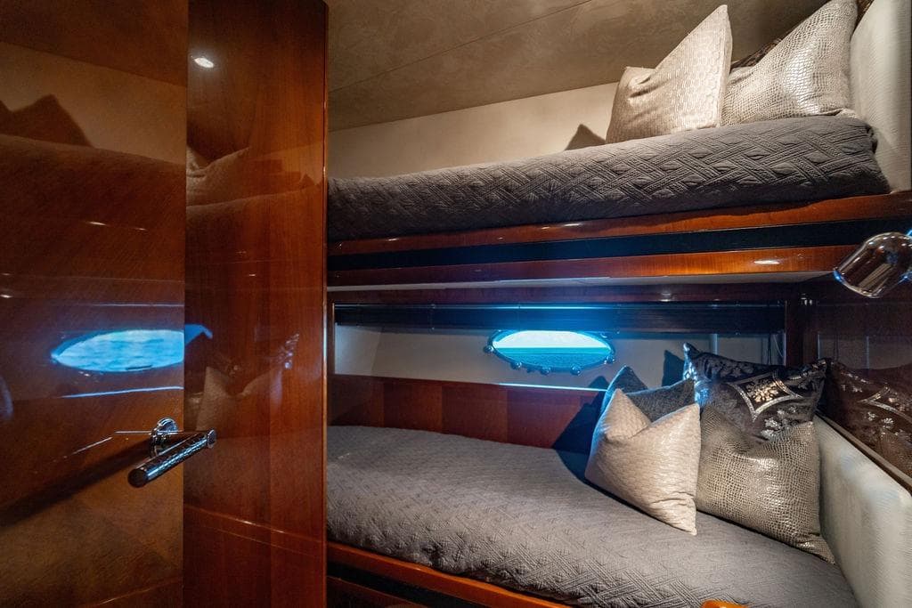 Luxurious cabin interior of 2010 Princess 95 Motor Yacht with bunk beds and elegant decor.