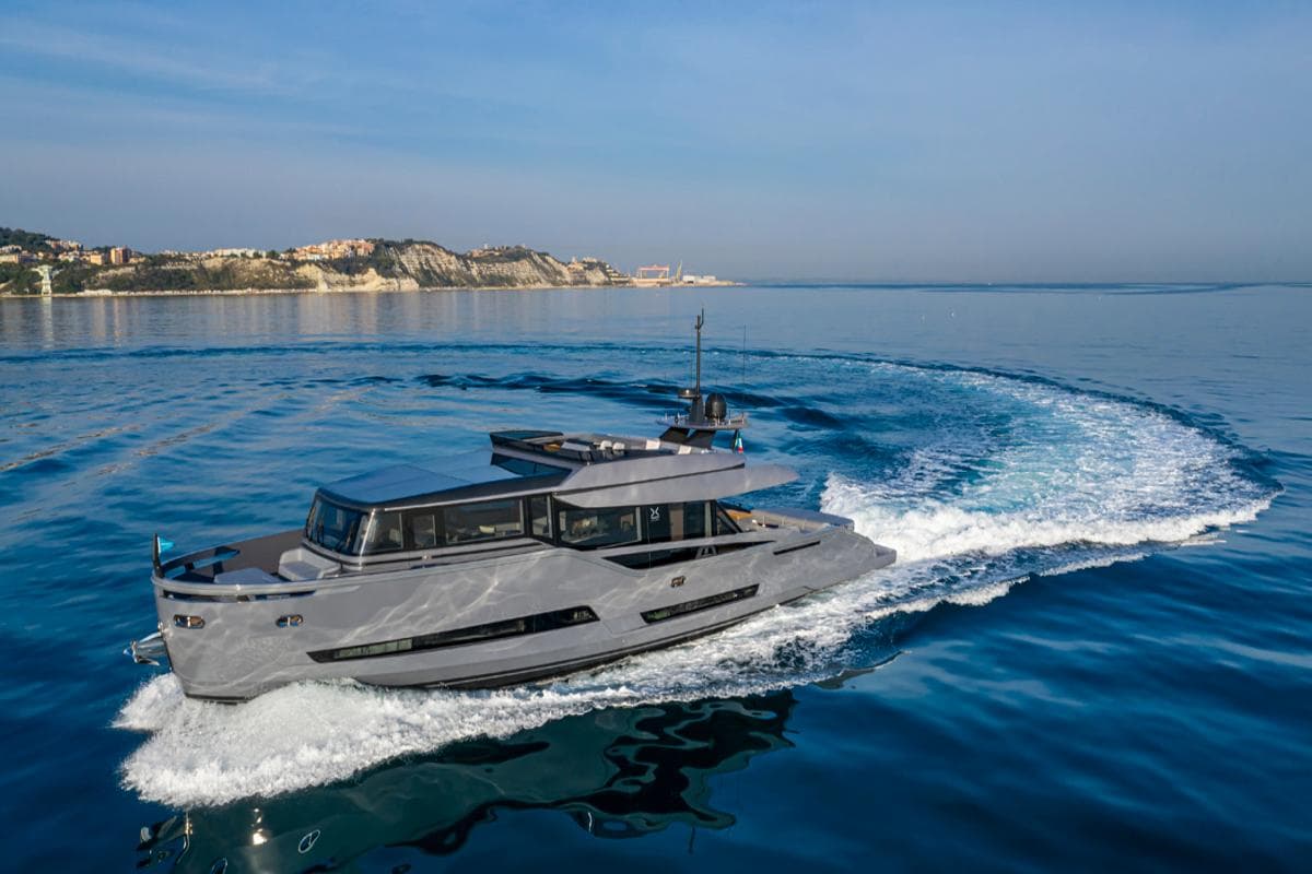 2021 Palumbo Extra 86 yacht cruising on calm blue waters near a scenic coastline.