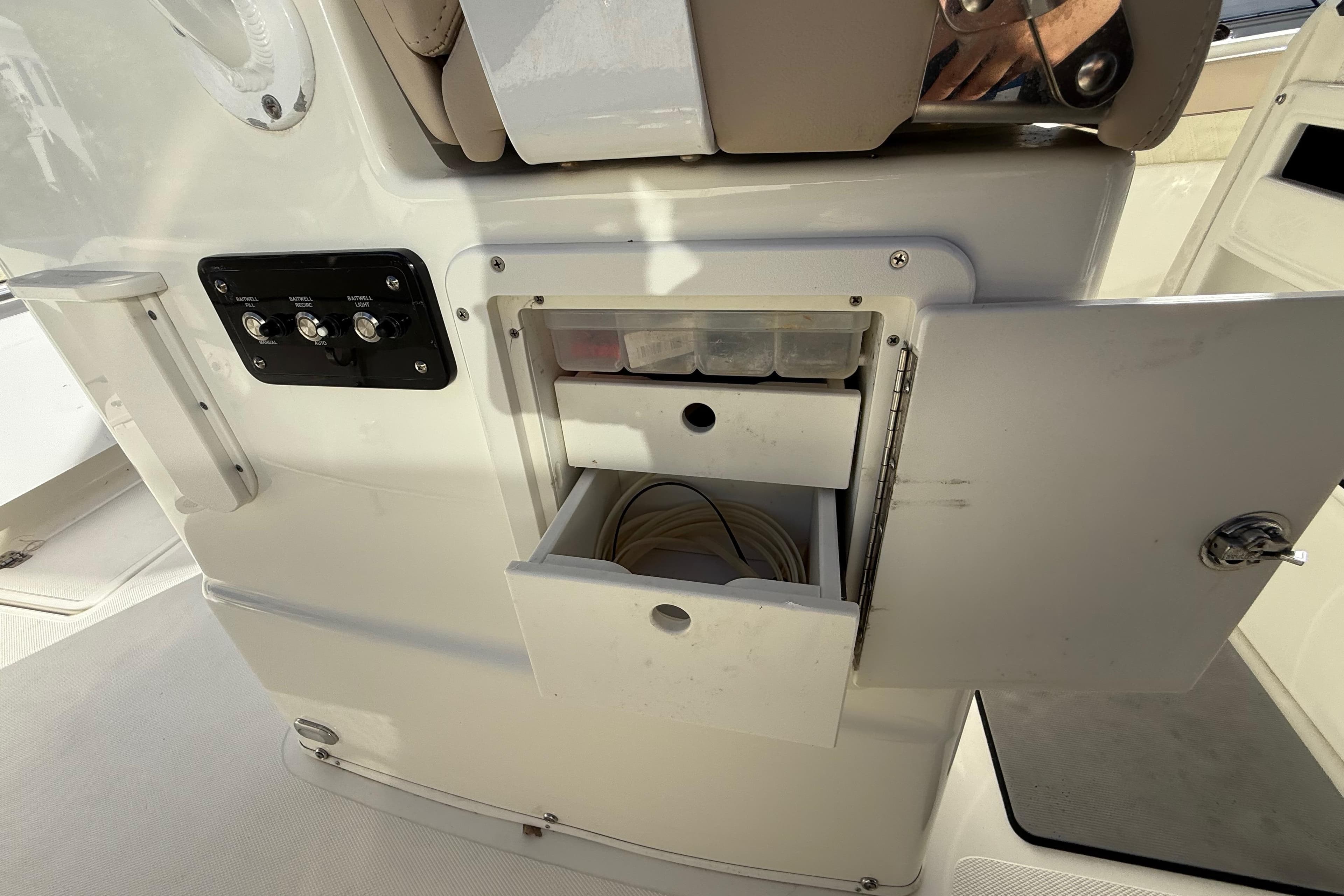 2018 NauticStar 28 XS boat storage compartment with open door and control panel.