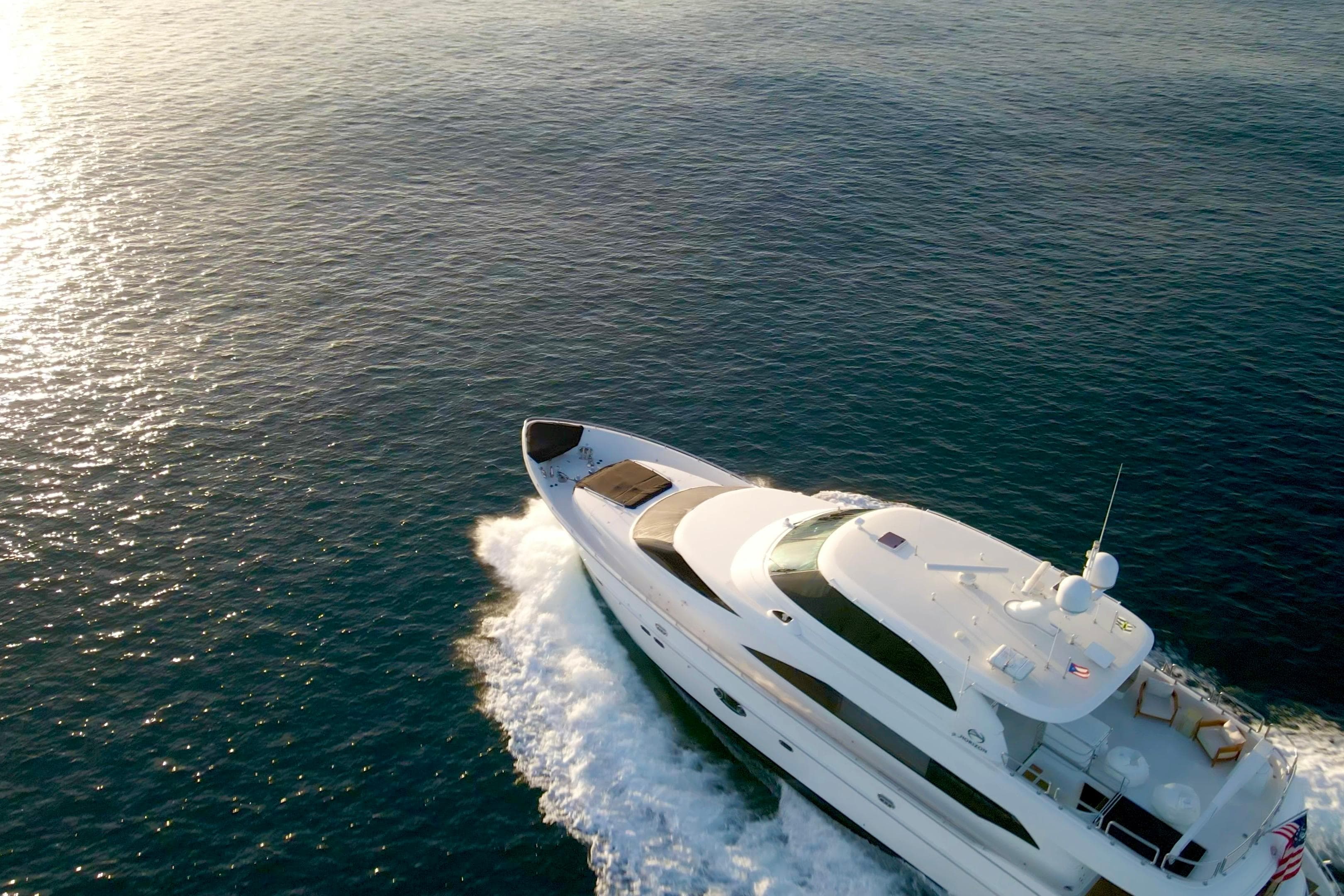 Luxurious 2011 Horizon E88 yacht cruising on open sea at sunset.