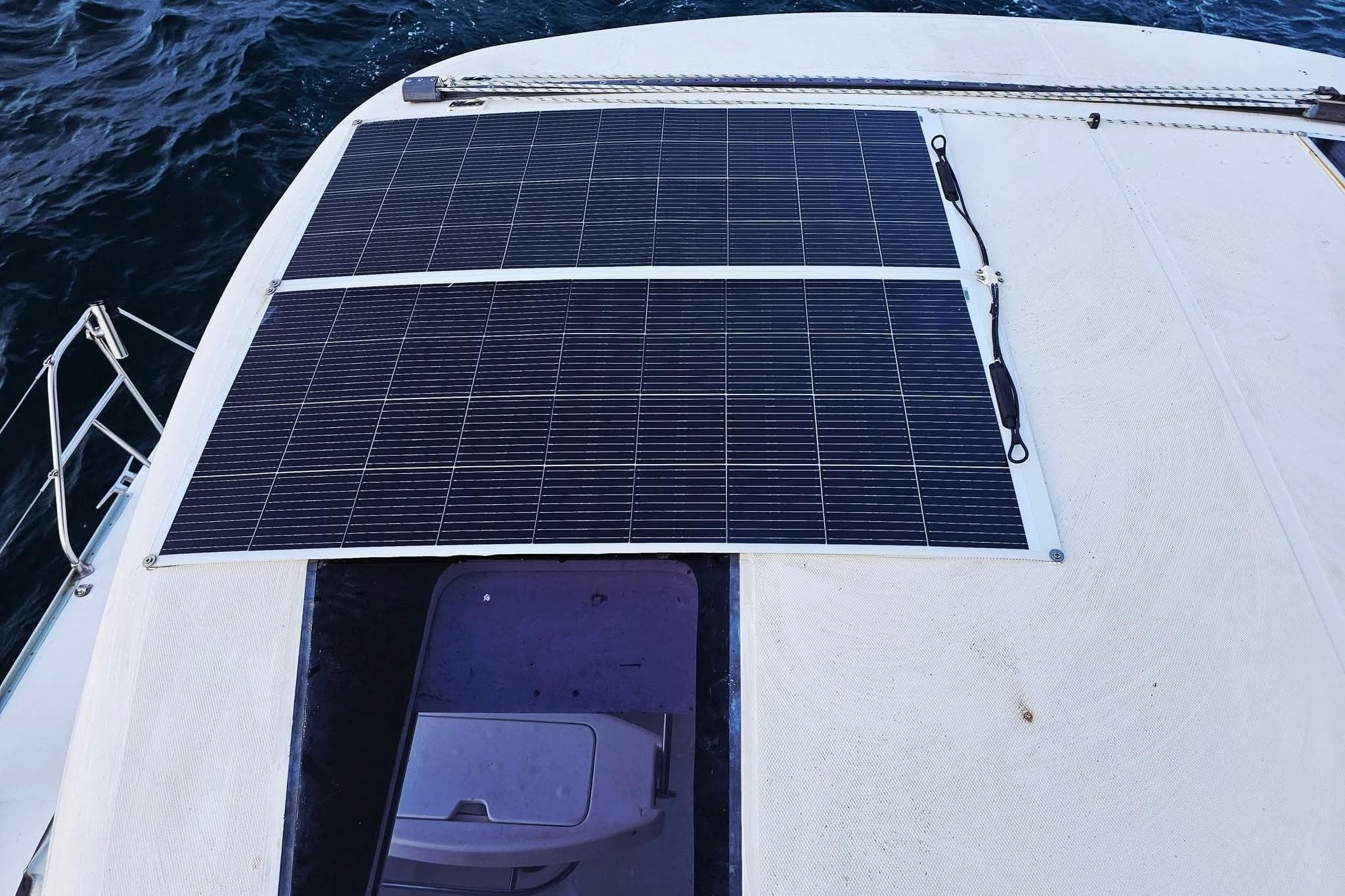 Solar panels on a 2007 Leopard 43 catamaran deck, near ocean water.