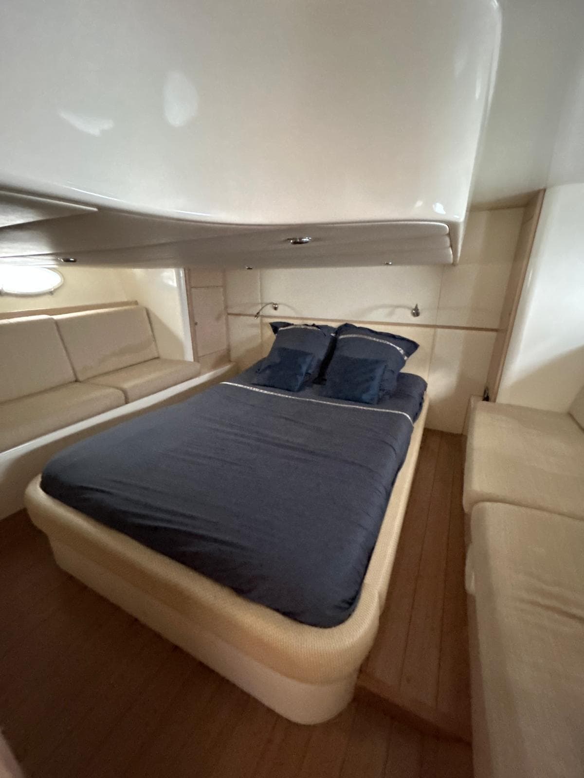 Luxurious cabin interior of 2010 Mig 43 yacht with cozy bedding and seating.