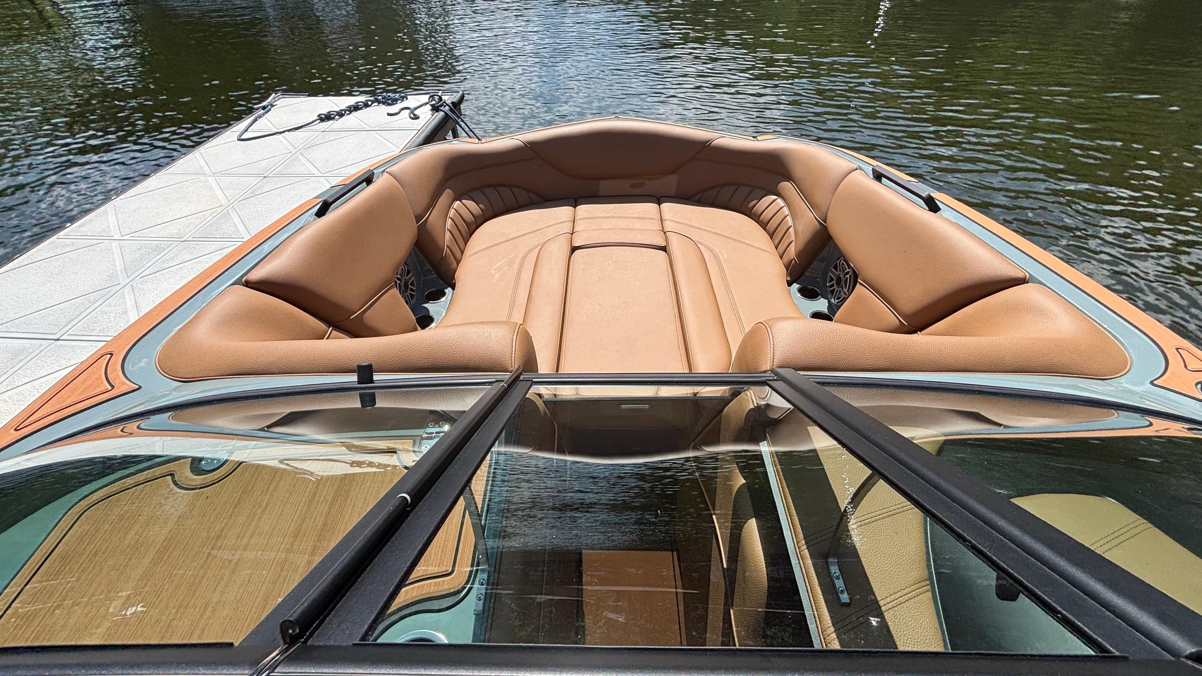 2025 MB B52 25 Alpha boat with tan leather seating, docked on calm water.