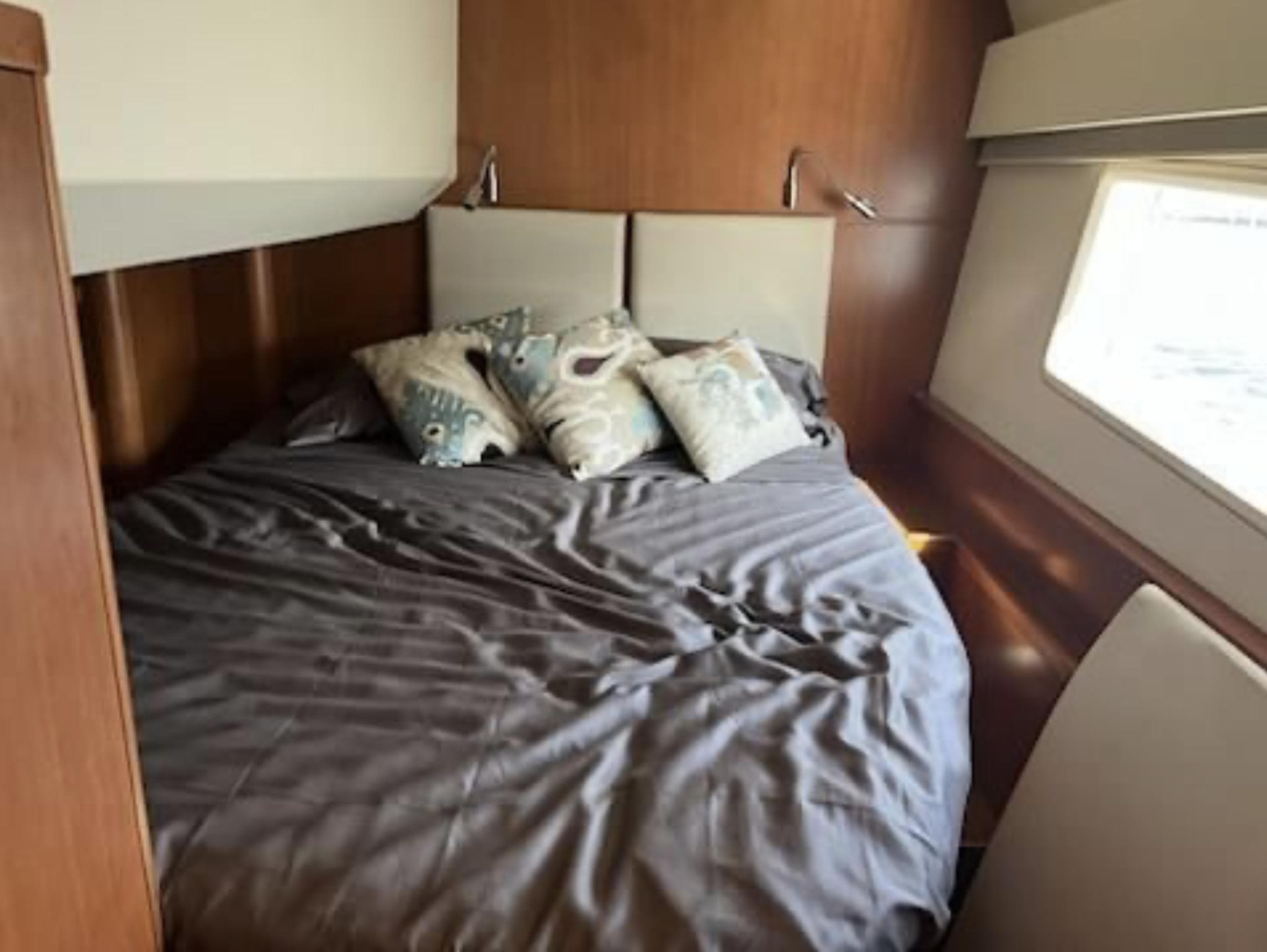 Luxurious bedroom interior of 2016 Aquila 44 Yacht with cozy bedding and decorative pillows.