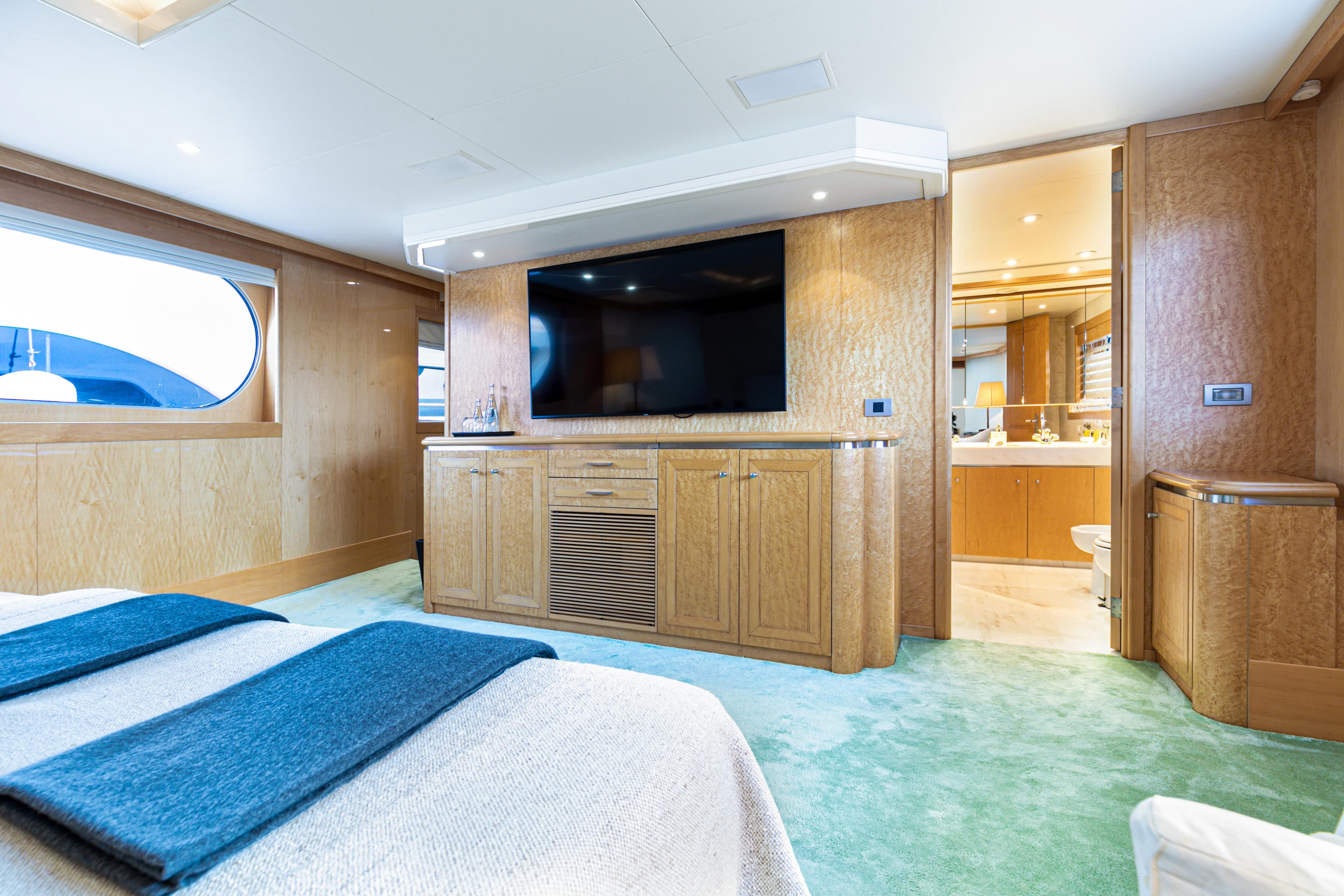 Luxurious Amels yacht interior, featuring a spacious bedroom with modern amenities and elegant wood finishes.