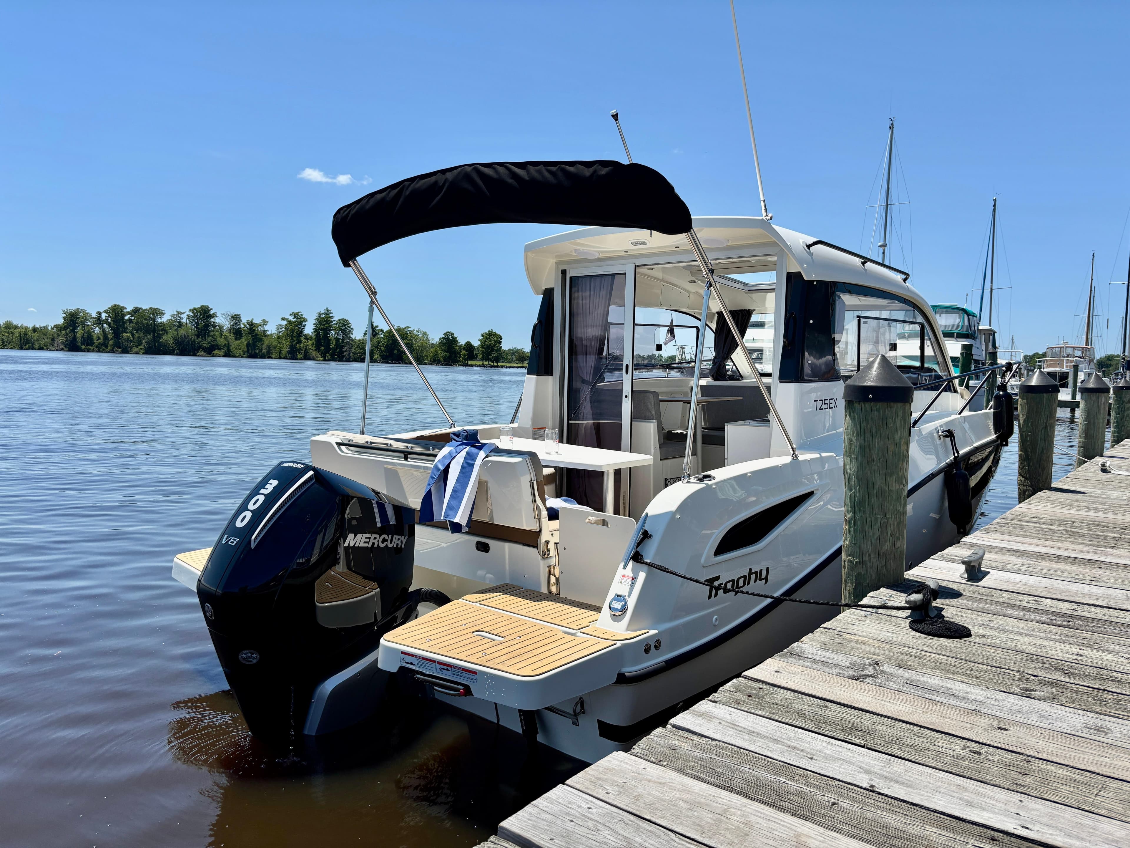 2025 Bayliner TROPHY 25 EXPLORER docked, featuring Mercury outboard engine, sunny day.