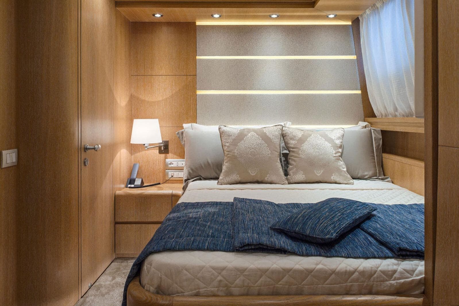 Luxurious bedroom interior on a 2001 Maiora 31 DP yacht, featuring elegant wood paneling.