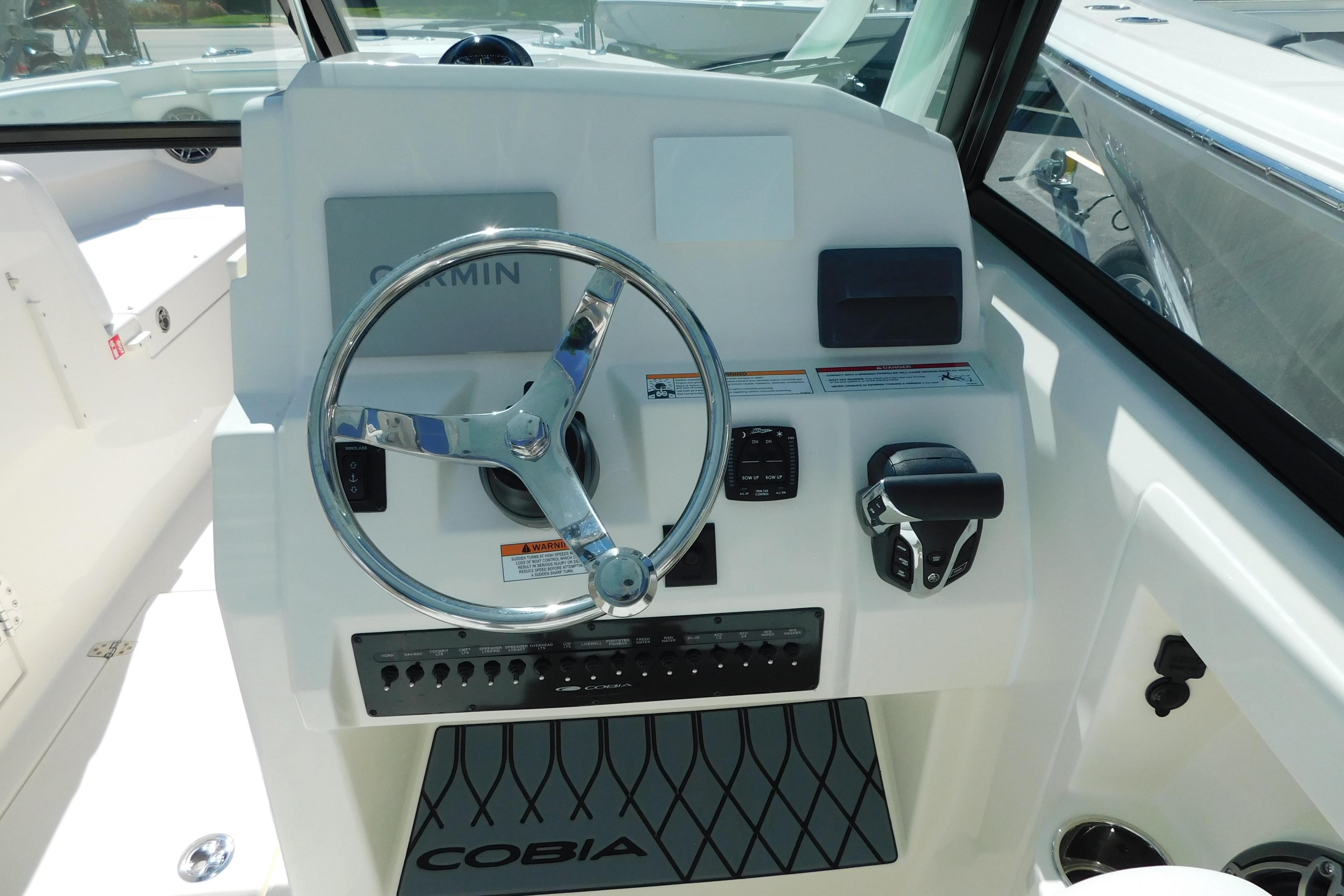 2026 Cobia 240 Dual Console boat dashboard with steering wheel and controls.