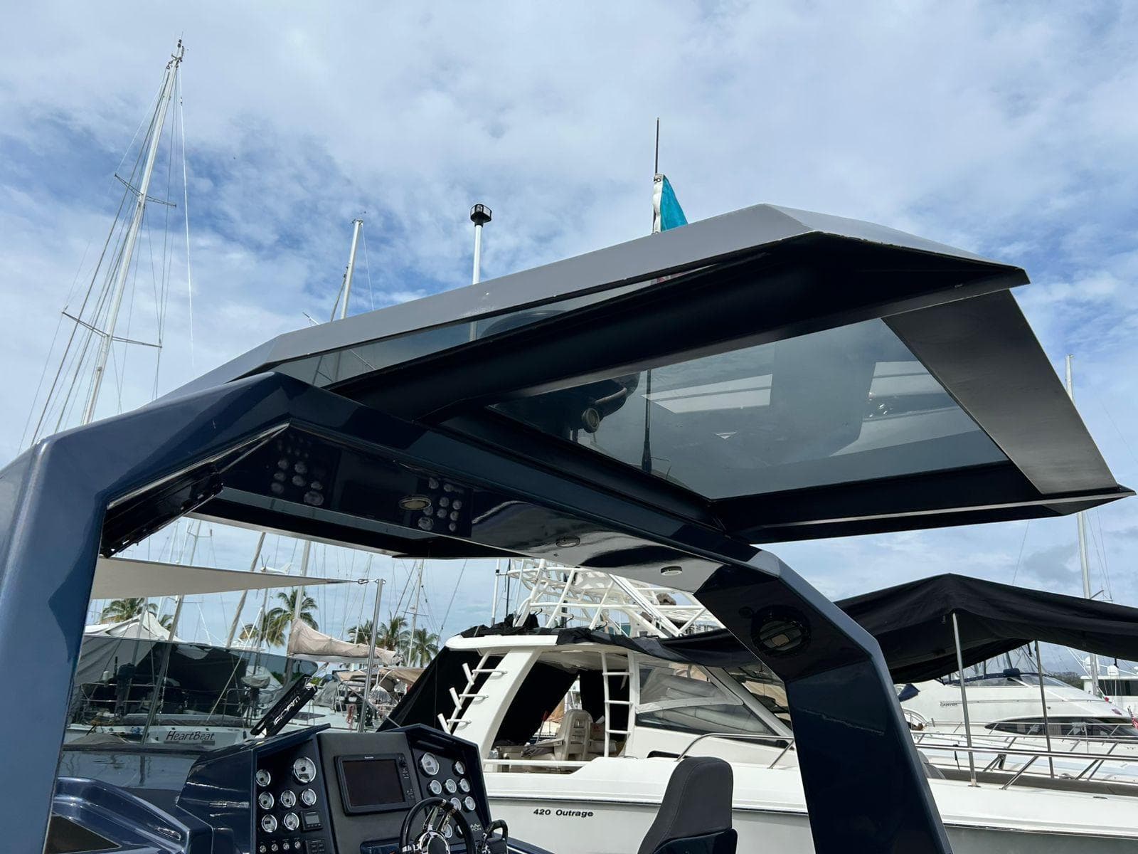 2016 Maori 50 yacht helm with modern design, docked at marina under cloudy sky.