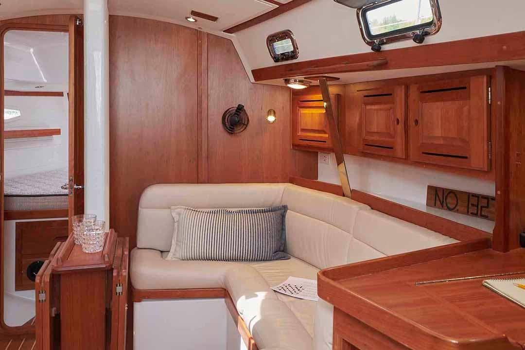 Luxurious 2022 Tartan 365 yacht interior with wooden cabinetry and plush seating.