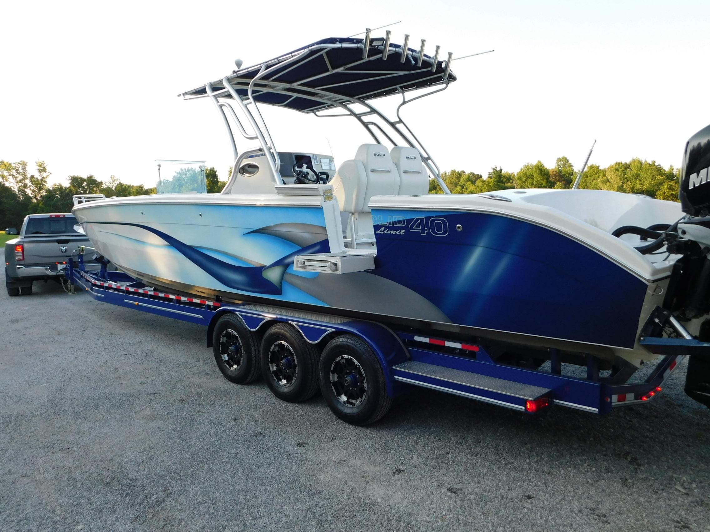 2005 Solid Craft LIMITED 40 boat on trailer, featuring sleek blue design and triple-axle support.