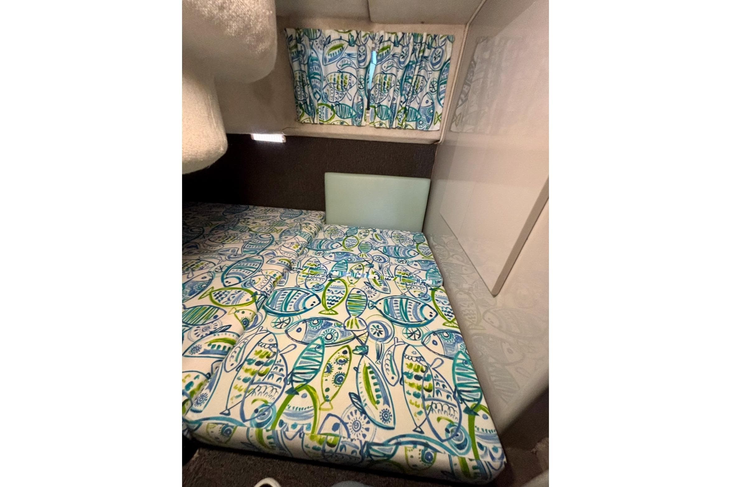 1992 Tiara Sport 270 Sport cabin interior with colorful fish-patterned bedding and curtains.