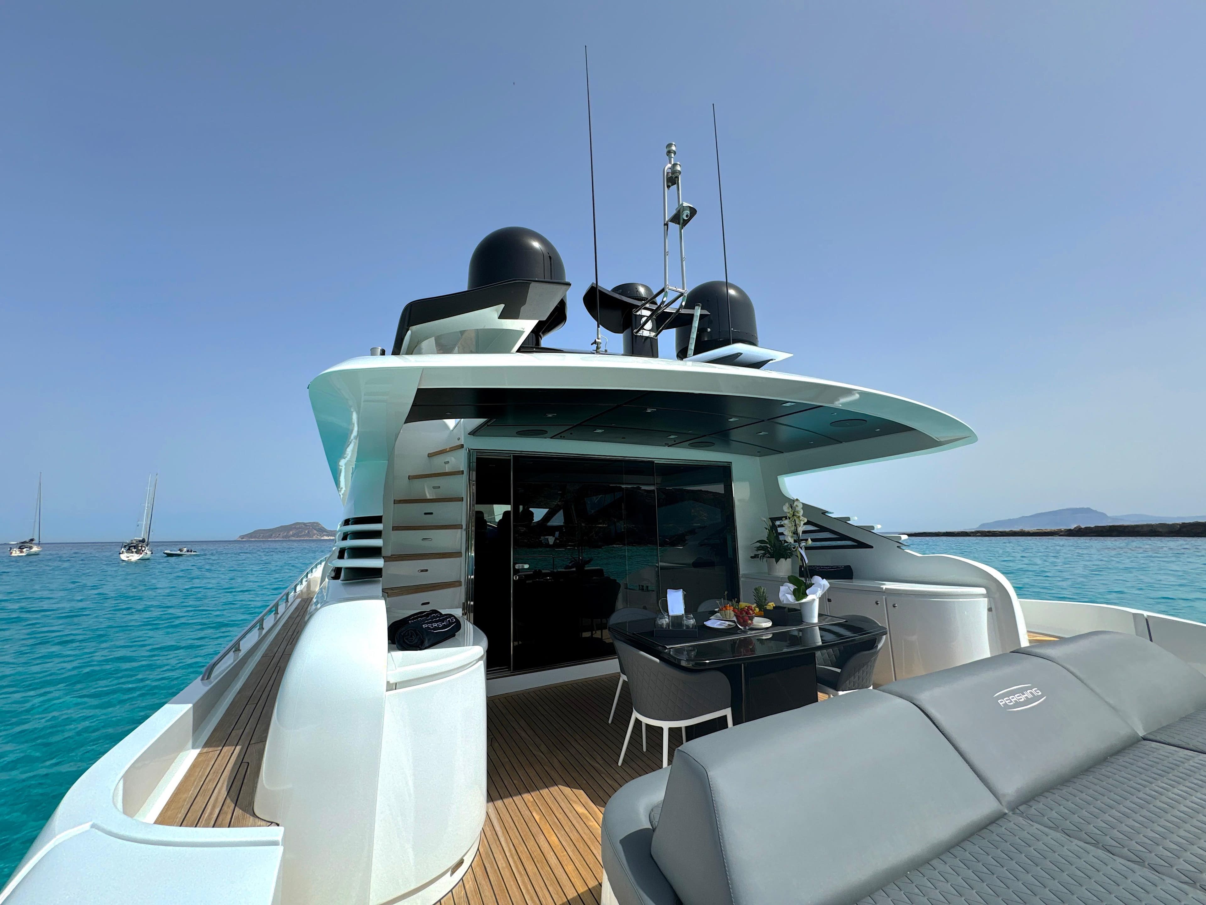 2008 Pershing 90 yacht on turquoise water, featuring sleek design and outdoor seating area.