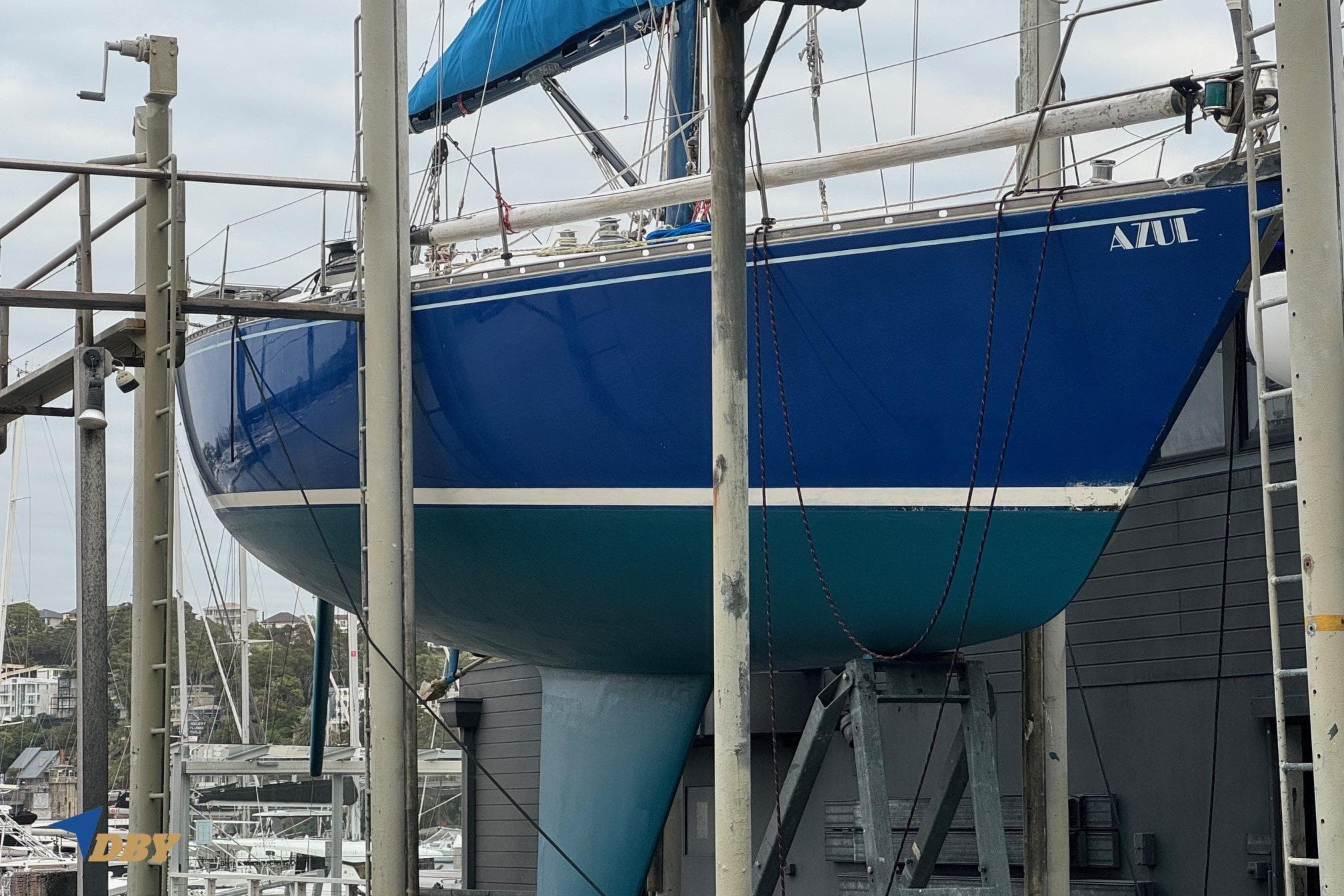 Blue 1981 Baltic 42 sailboat named "Azul" on a boat lift at a marina.