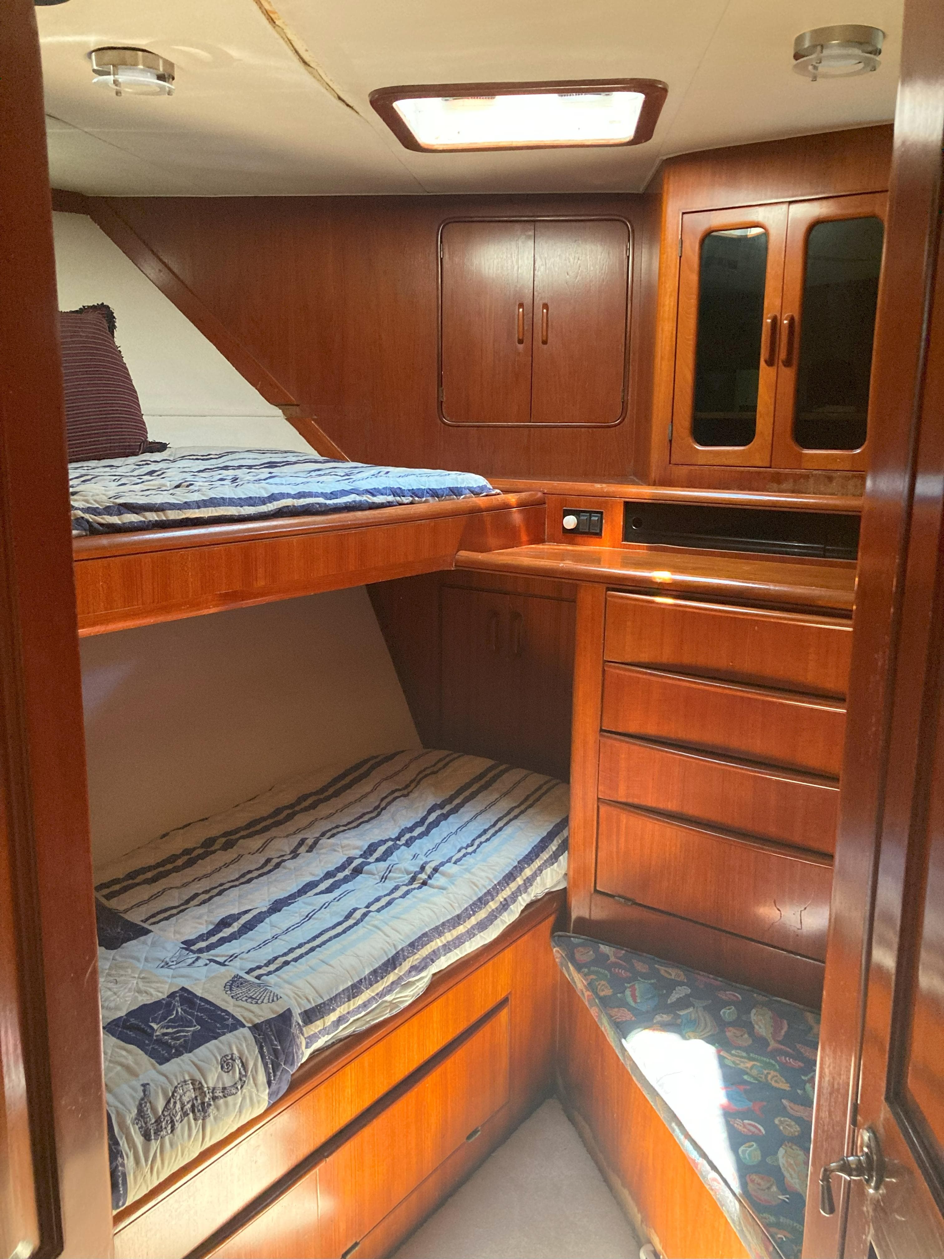 1988 Viking 70 Cockpit Motor Yacht cabin with wooden bunk beds and storage.