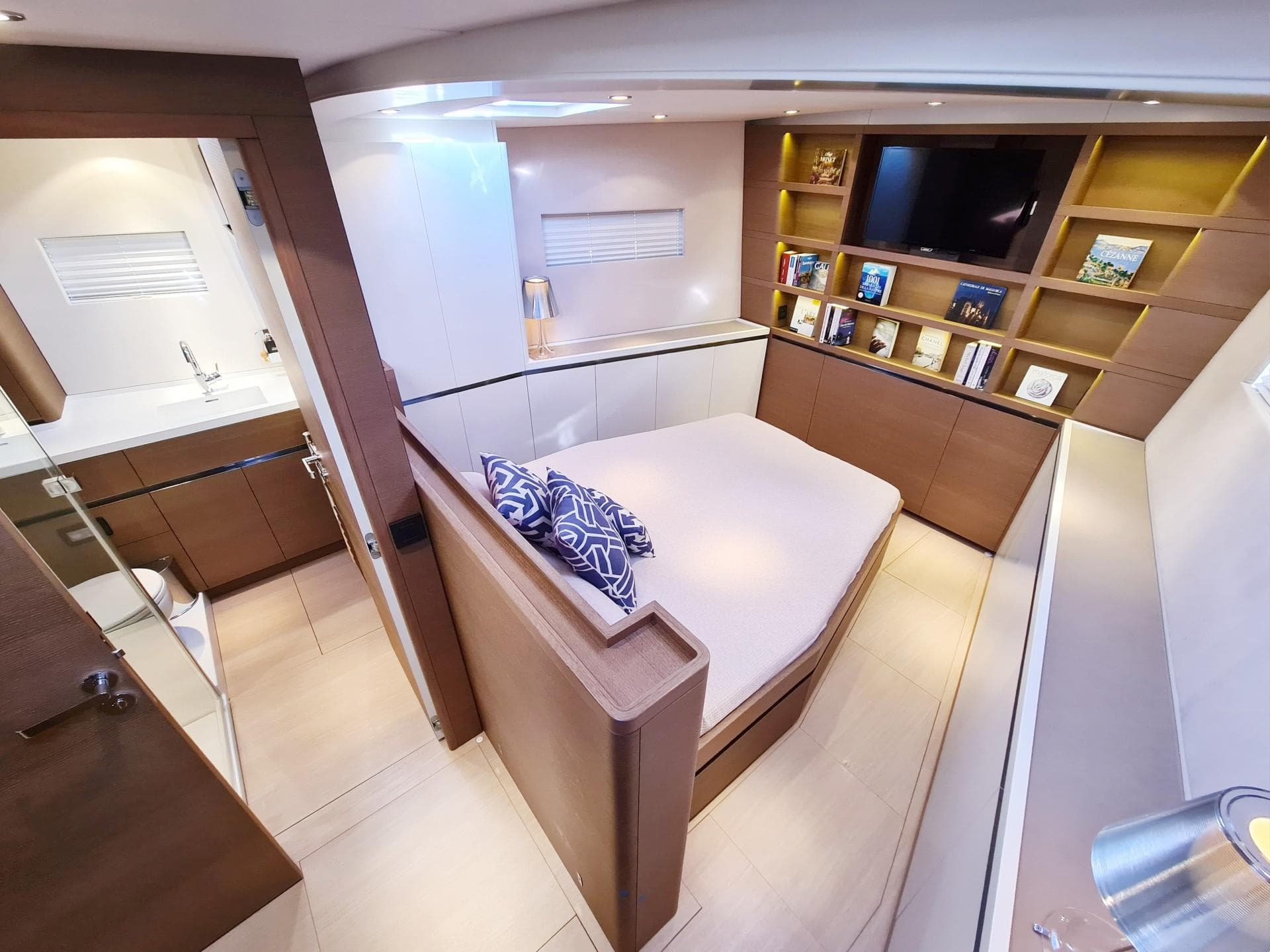 Luxurious cabin interior of 2017 CNB 76 yacht with modern furnishings and cozy bed.