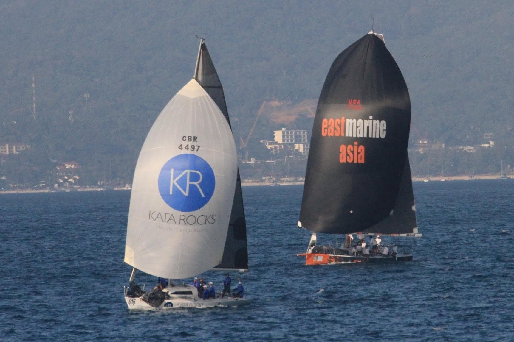 Sailboats racing on the ocean, featuring "Kata Rocks" and "East Marine Asia" sails, 1986 model.