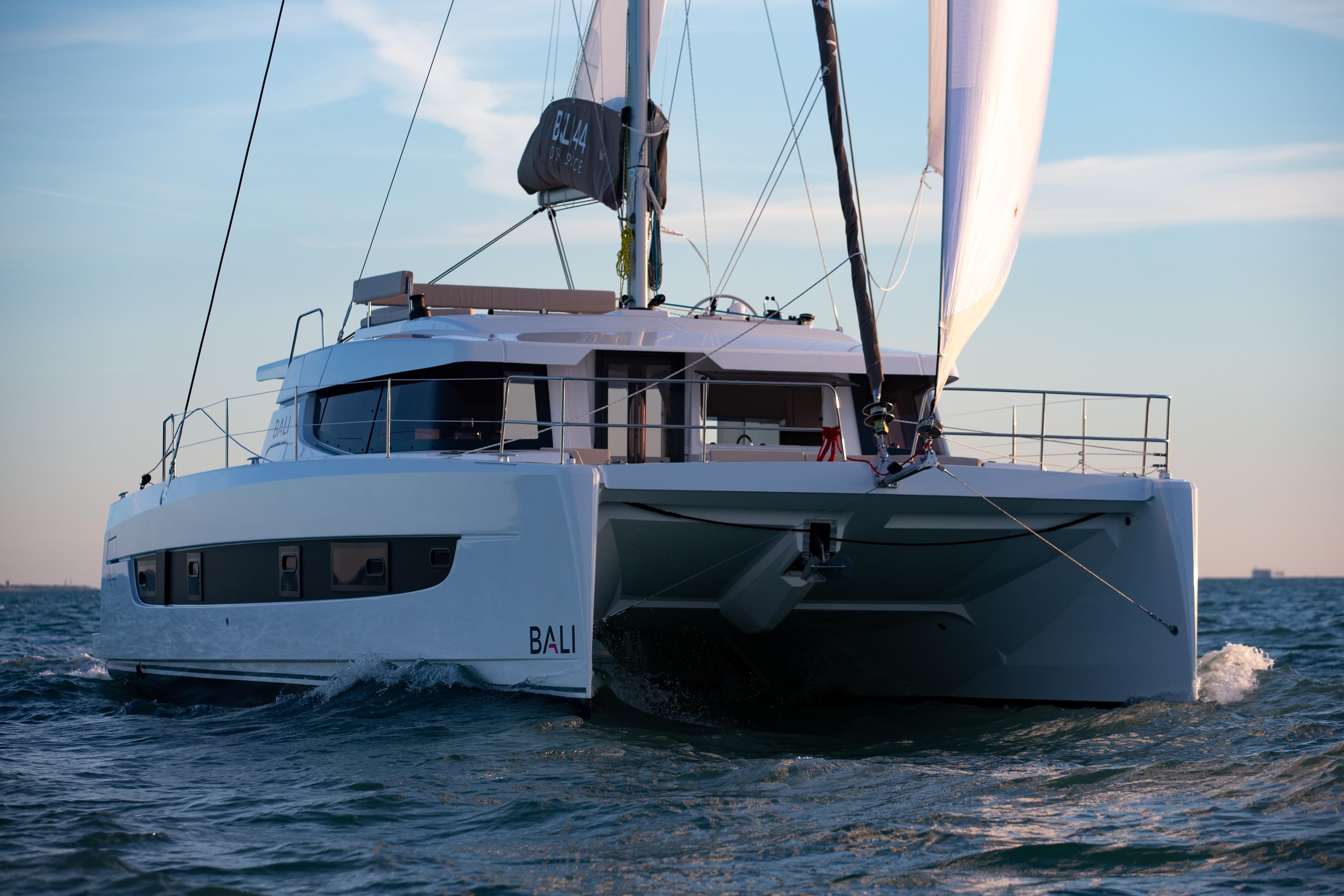 Modern Bali 4.4 catamaran sailing on open sea, 2026 model, under clear blue sky.