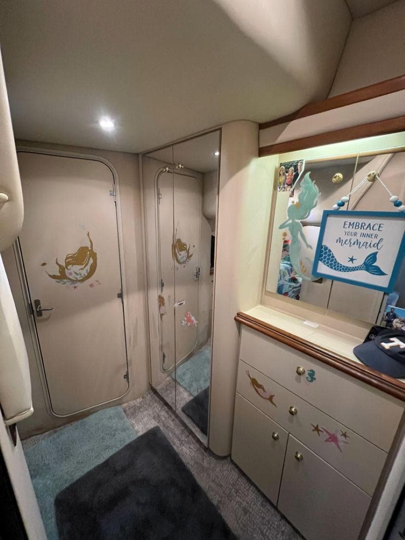 Interior of 2000 Cruisers Yachts 4270 Express with mermaid-themed decor and mirrored closet.