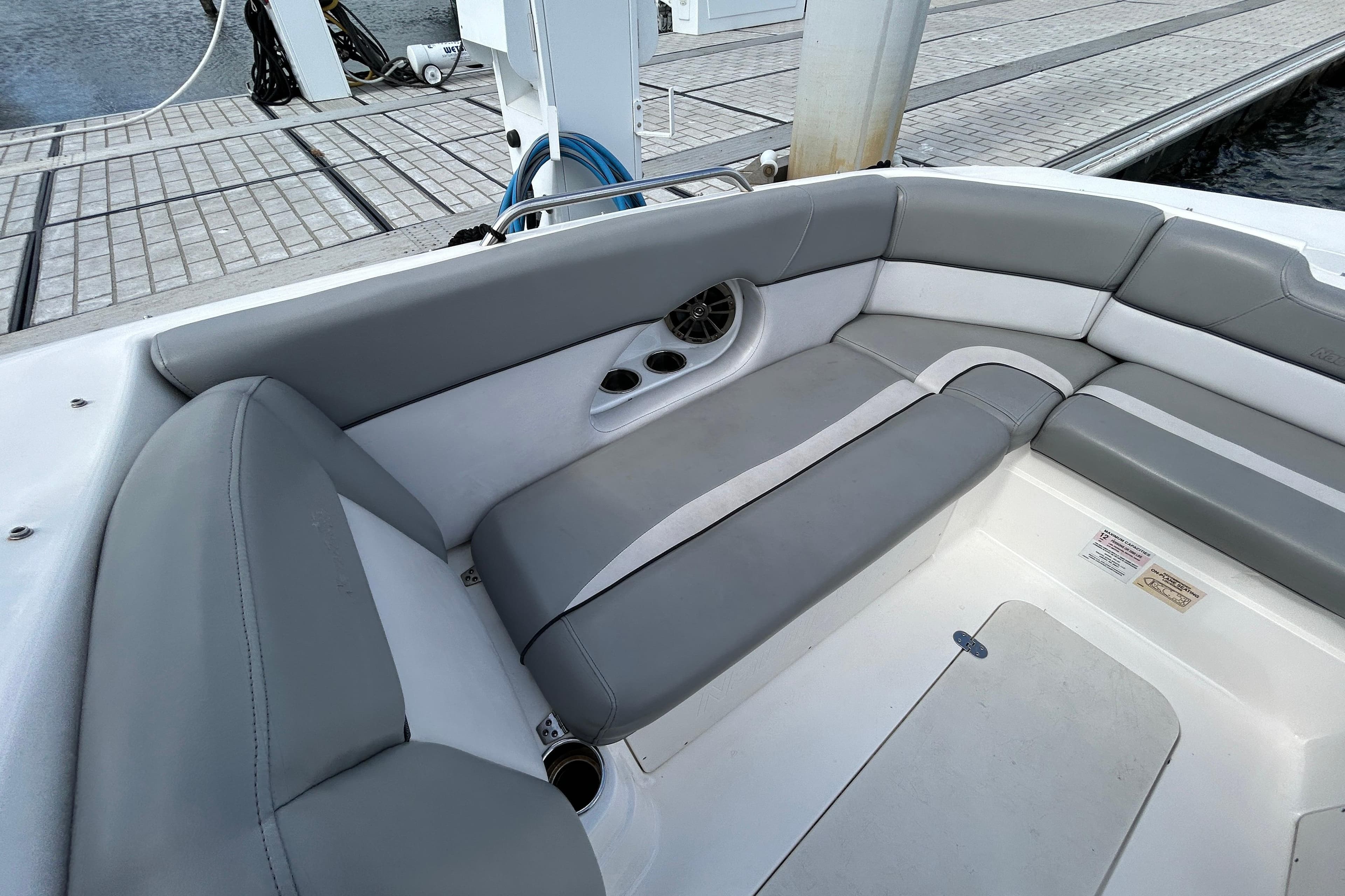 2022 NauticStar 243 DC boat interior with gray seating and cup holders at dock.