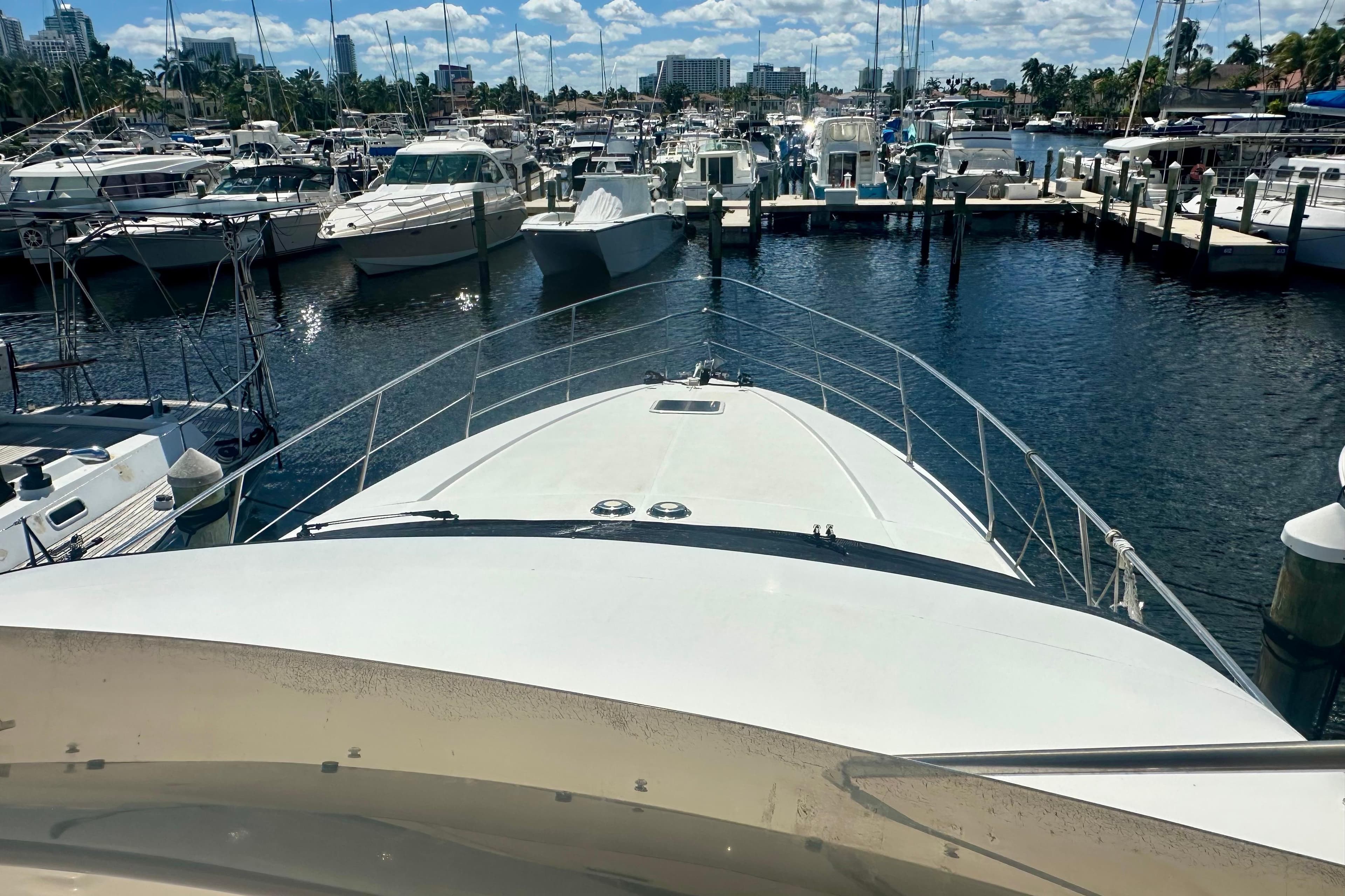 1999 Azimut 58 yacht docked in a marina with surrounding boats.