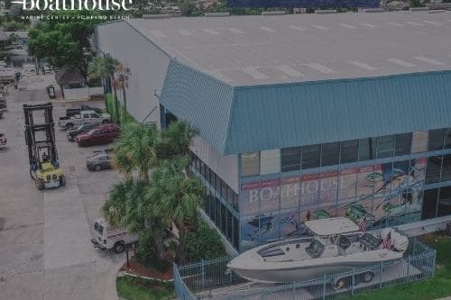 2017 Robalo R305 Walkaround boat displayed outside a large blue-roofed building.