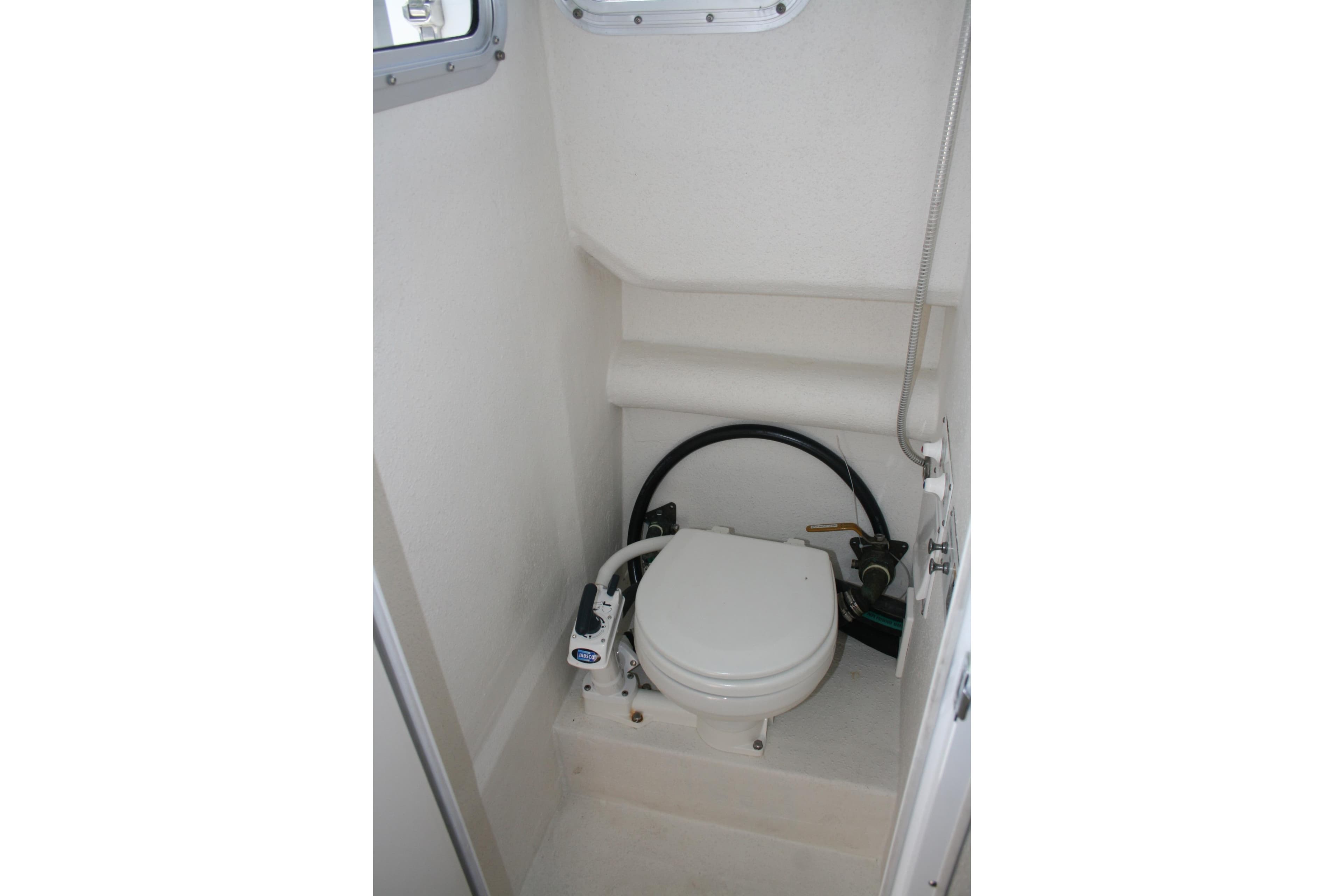 2003 SeaSport Explorer 2400 boat interior with compact marine toilet.