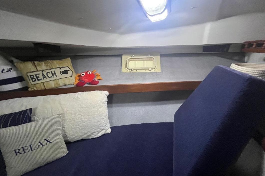 1976 Uniflite 32 Sport Sedan cabin with nautical-themed pillows and cozy seating.