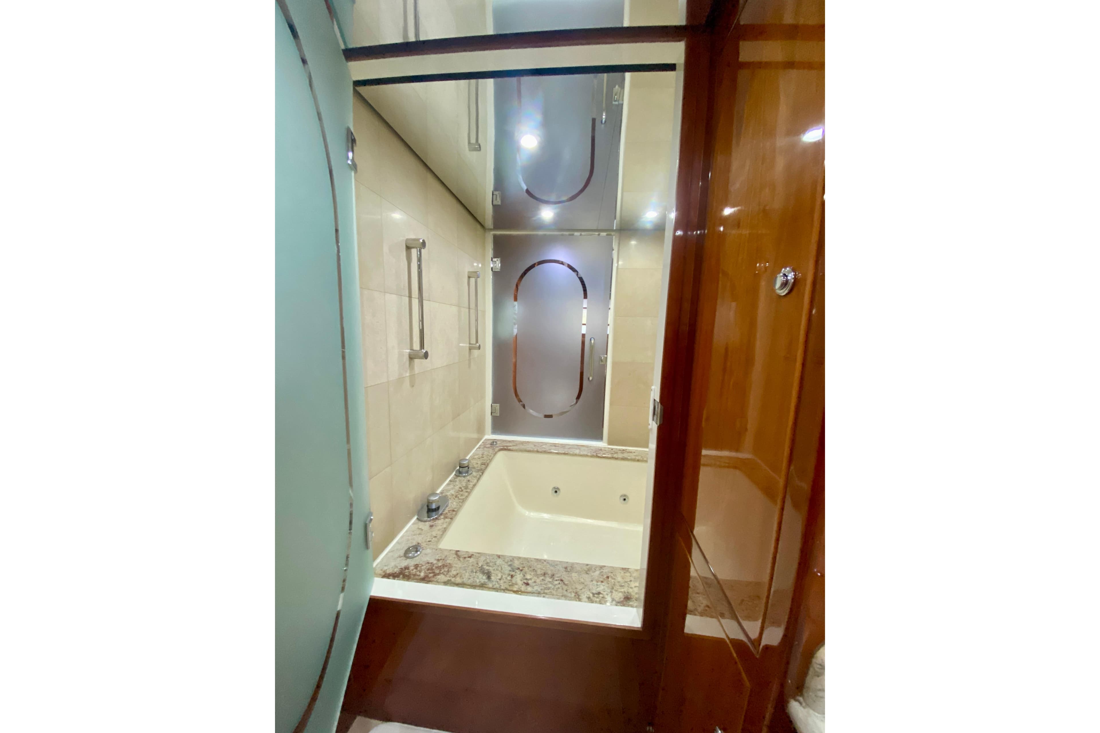 Luxurious bathroom with a marble tub in a 2001 Hargrave 94 yacht.